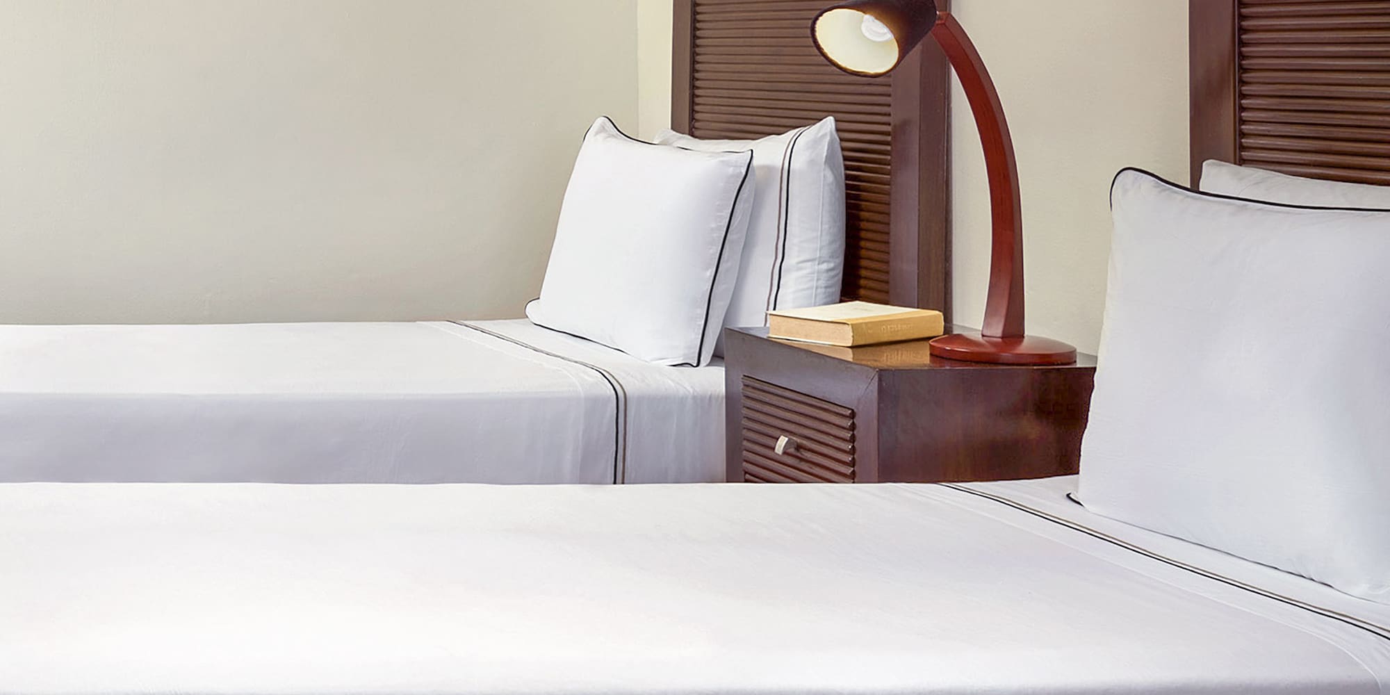 a room with two beds and a lamp