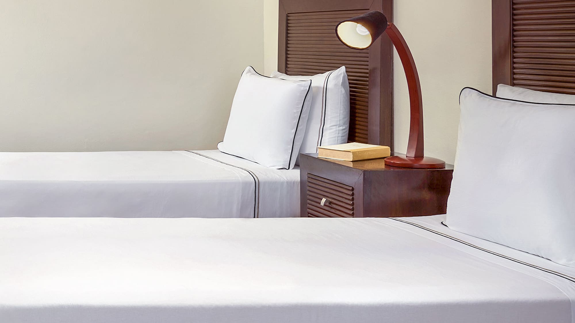 a room with two beds and a lamp