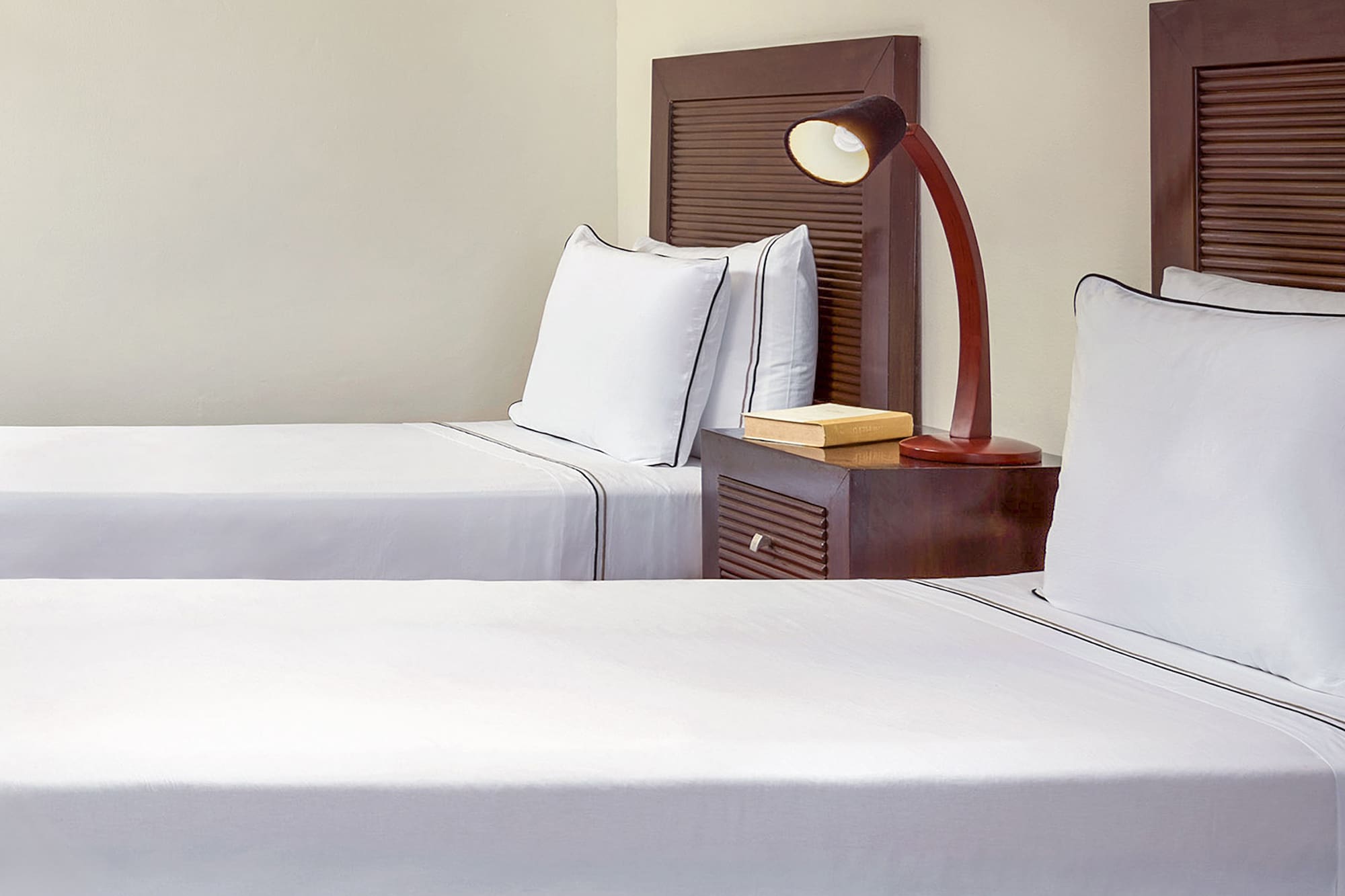 a room with two beds and a lamp