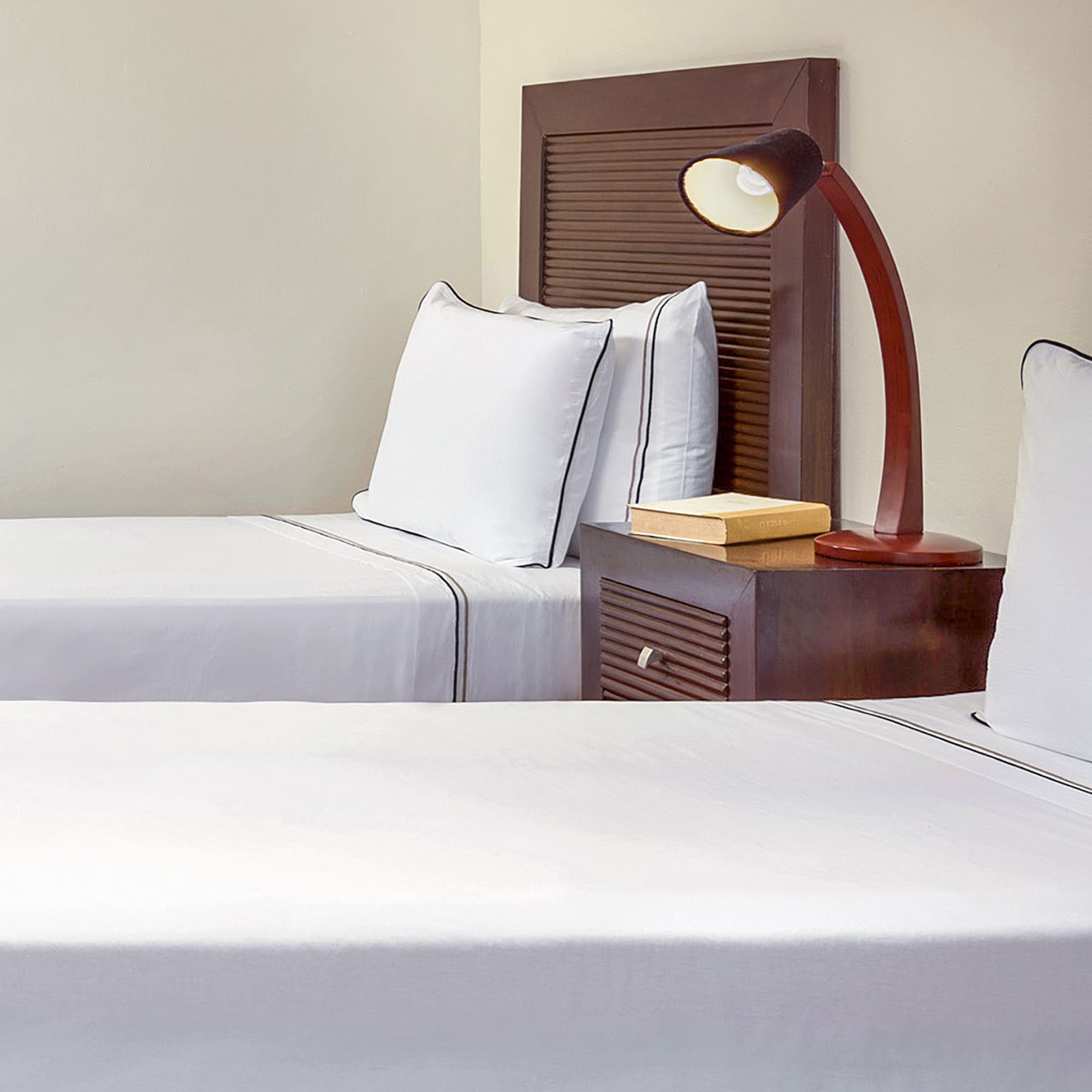 a room with two beds and a lamp