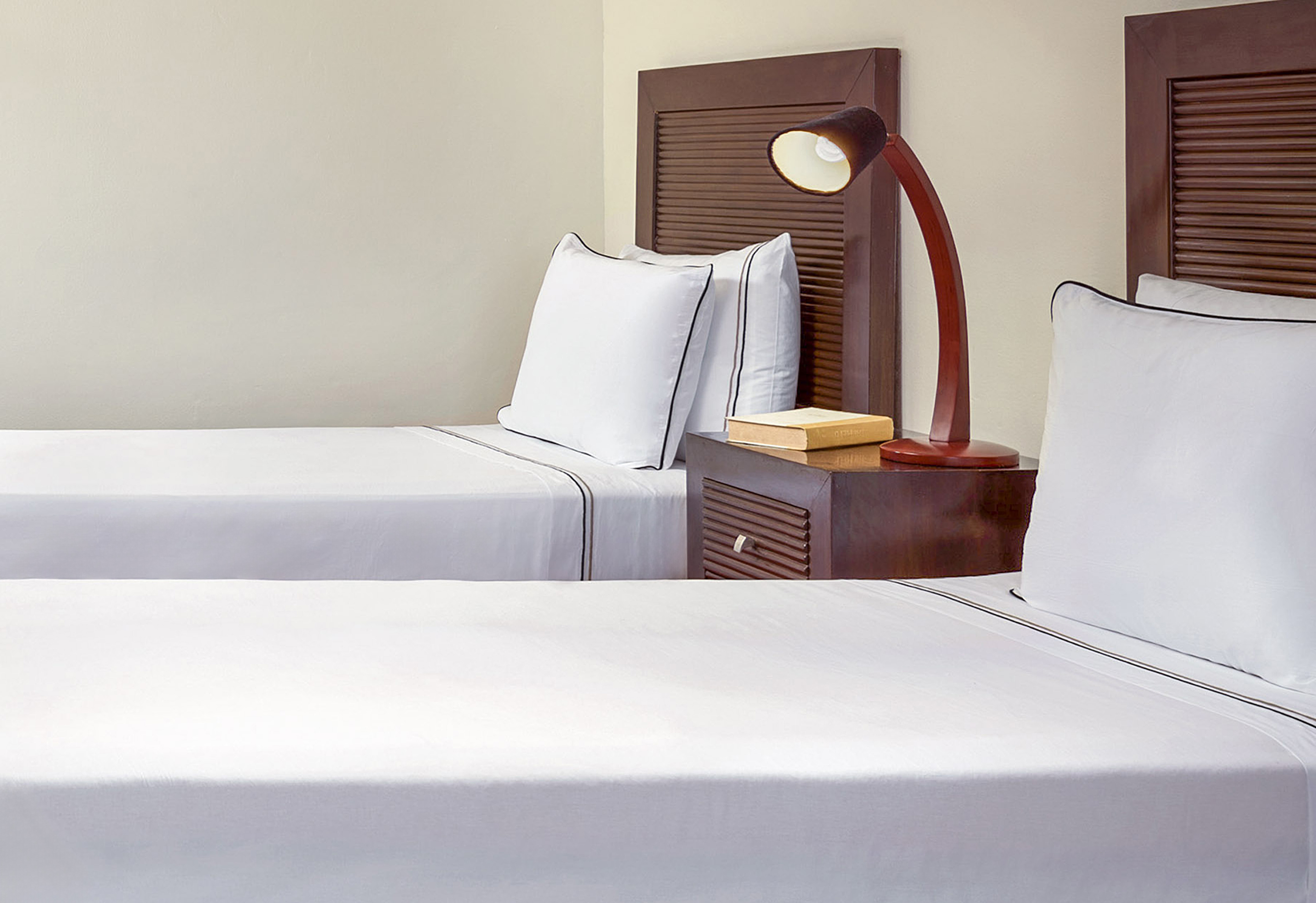 a room with two beds and a lamp