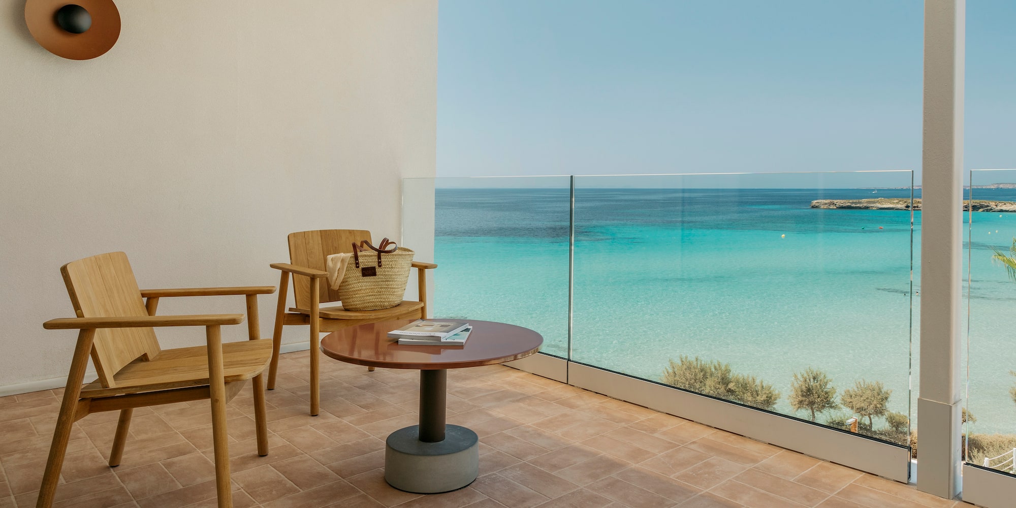 a balcony with a table and chairs and a beach view
