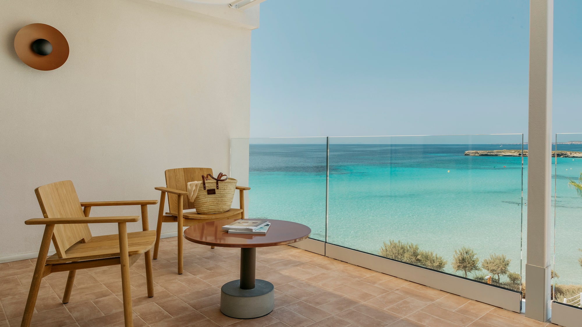 a balcony with a table and chairs and a beach view
