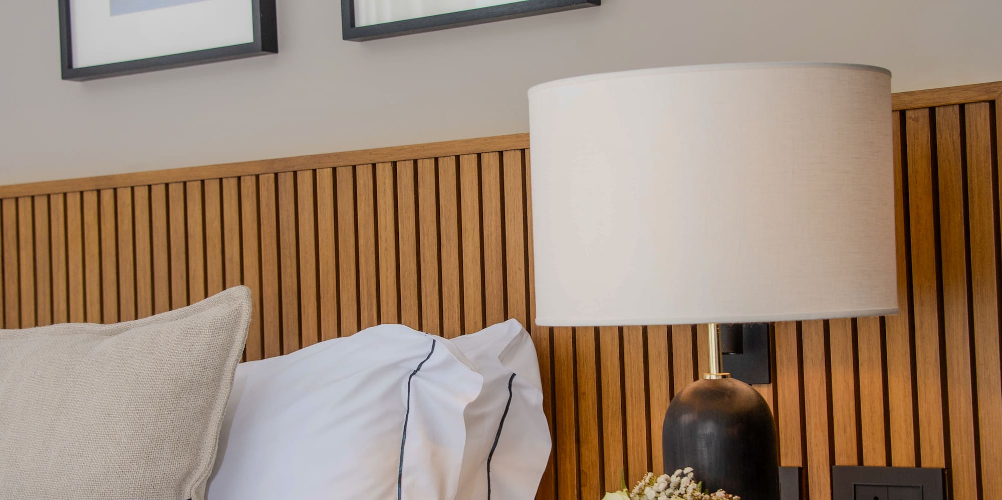 a bed with a lamp and flowers