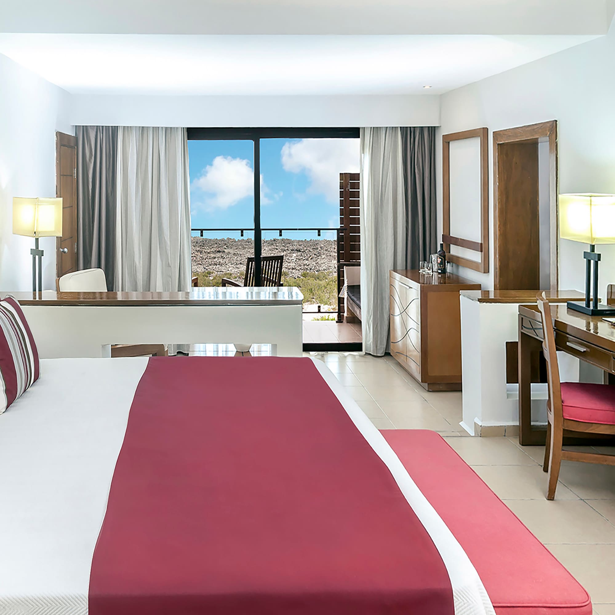a bedroom with a red bed and desk