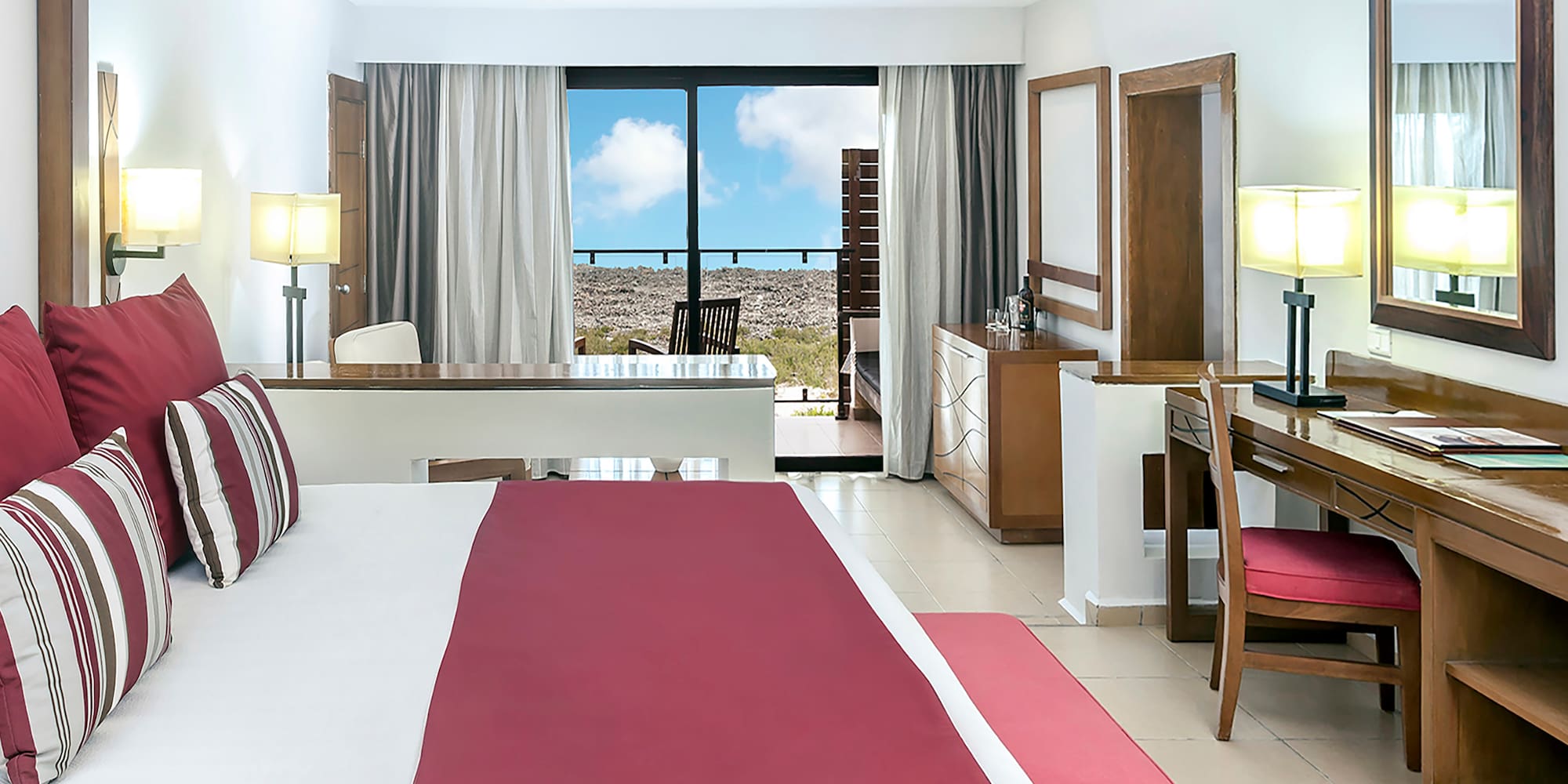 a bedroom with a red bed and desk