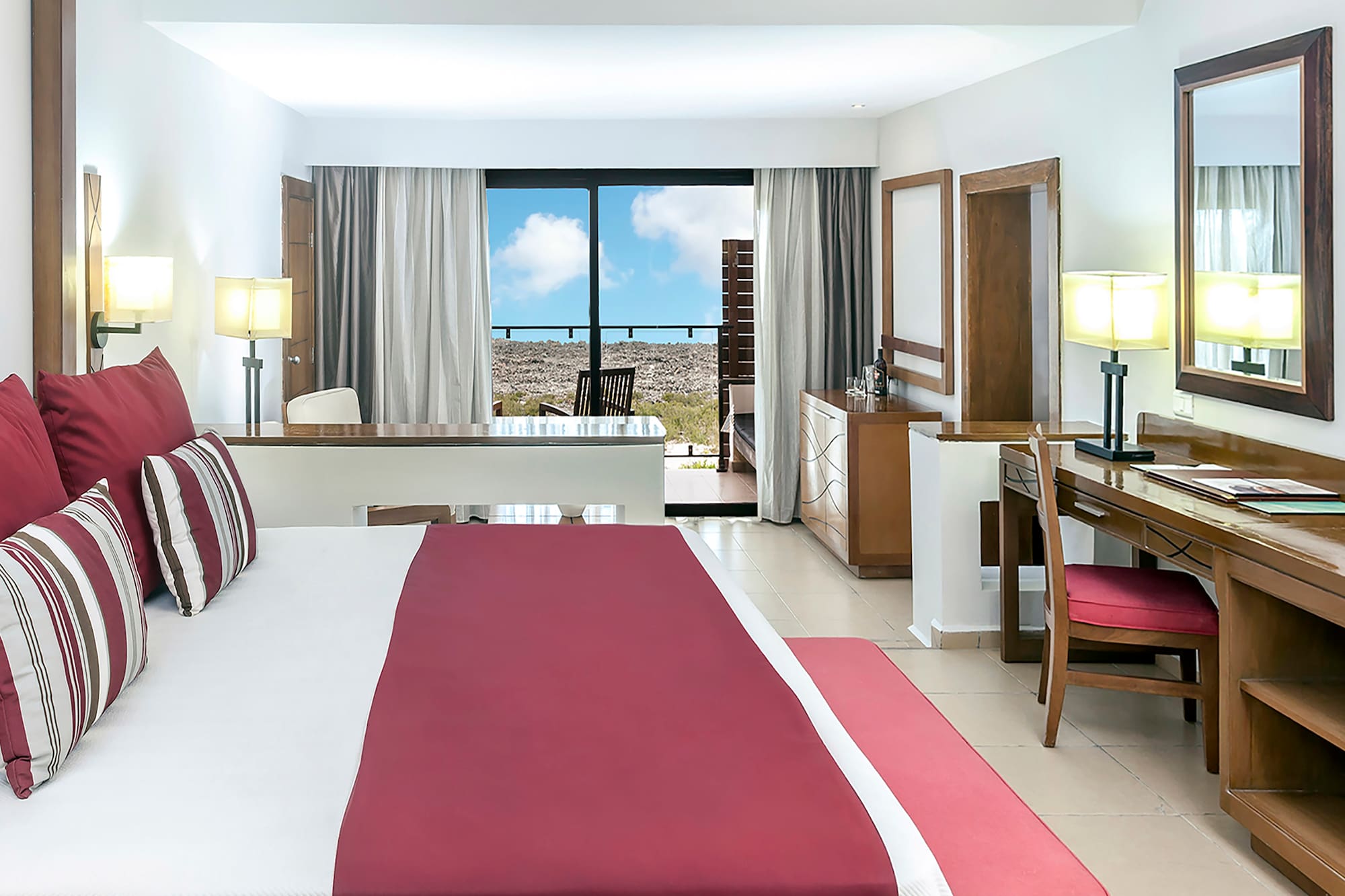 a bedroom with a red bed and desk