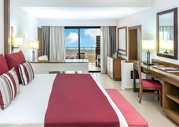 a bedroom with a red bed and desk