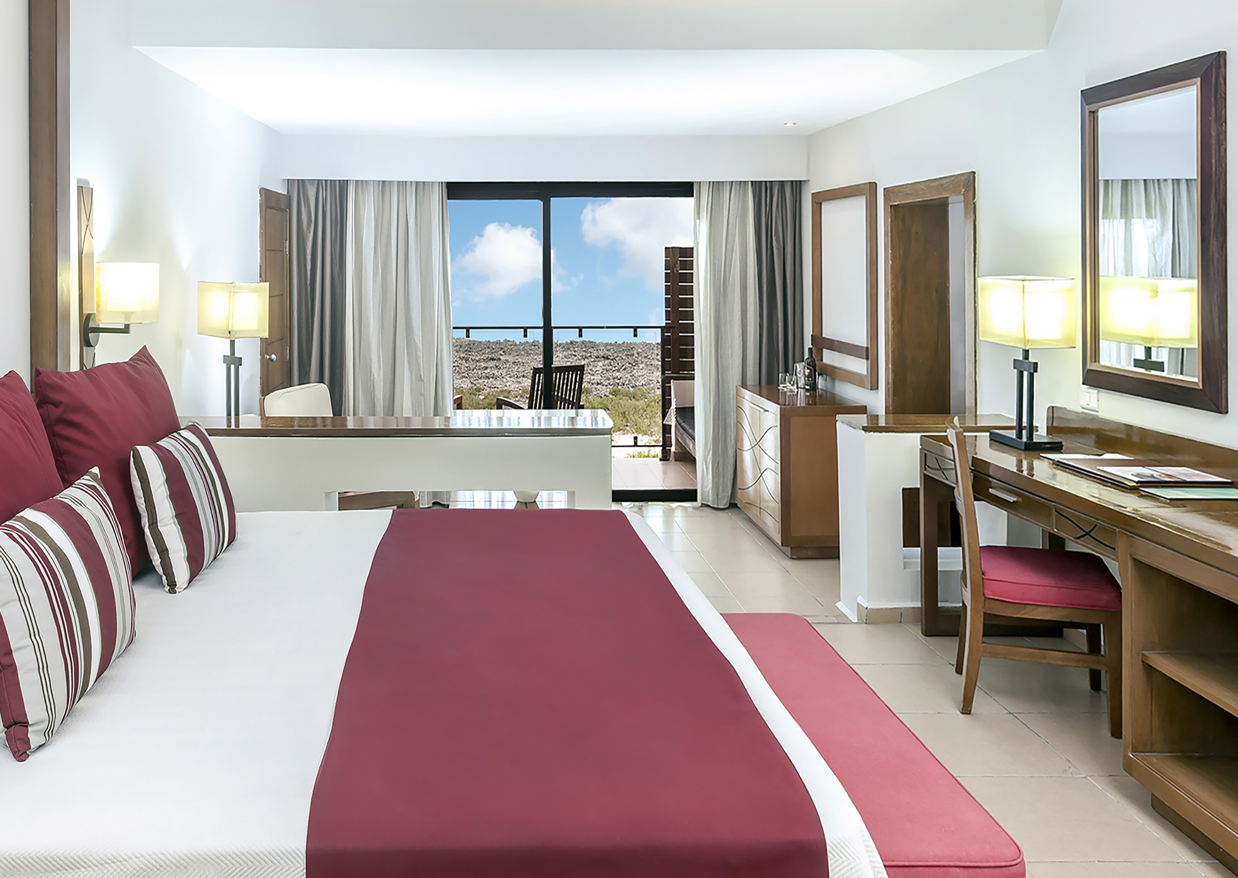 a bedroom with a red bed and desk