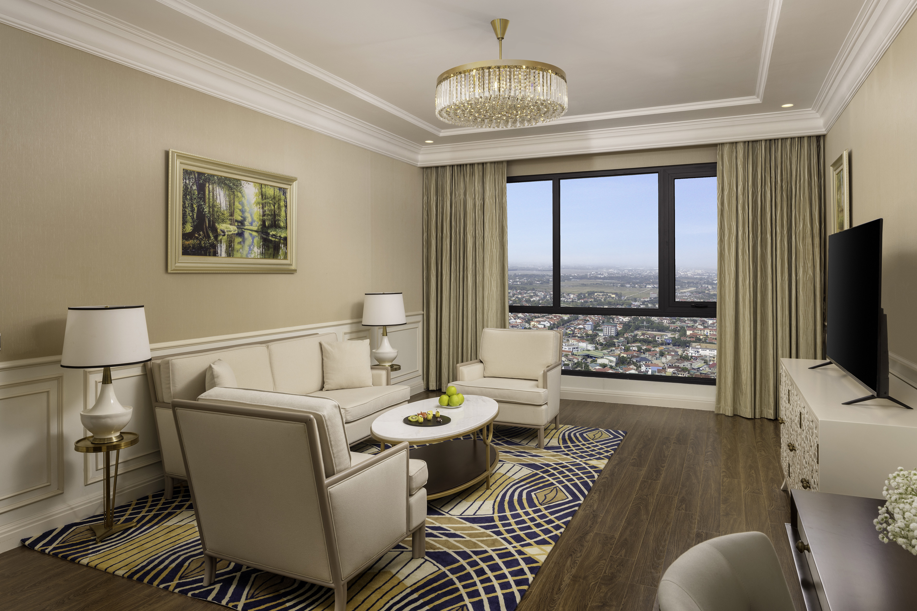 Luxury hotel suite living room with city view, elegant decor, and modern furniture.