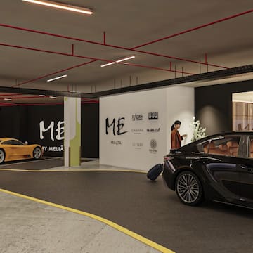 a car parking lot with a man standing in front of a car