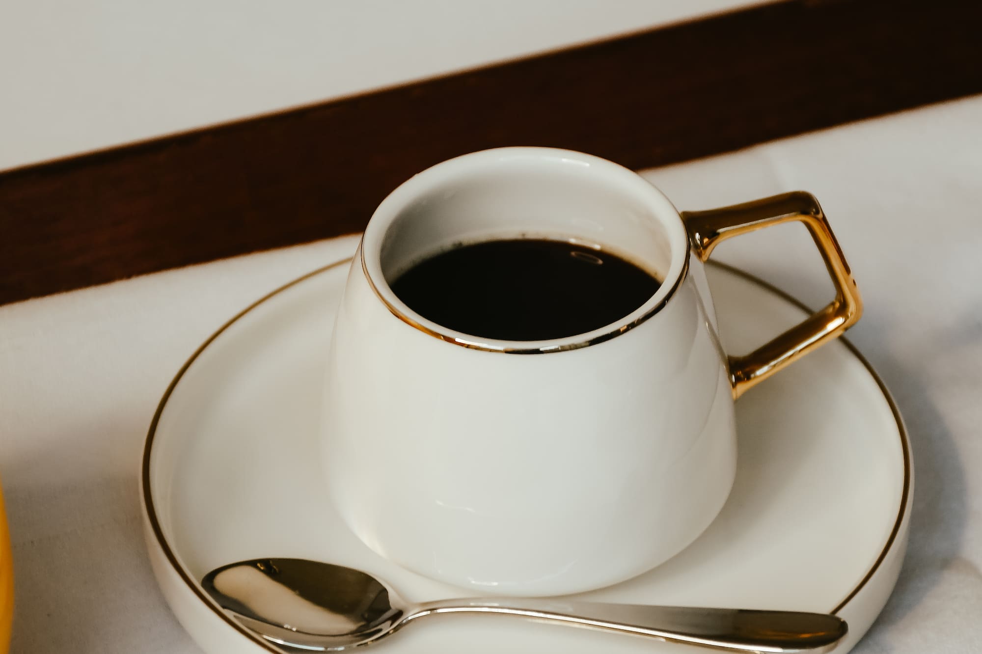 A couch sits with a coffee table in front of it, and a bag rests on the couch.