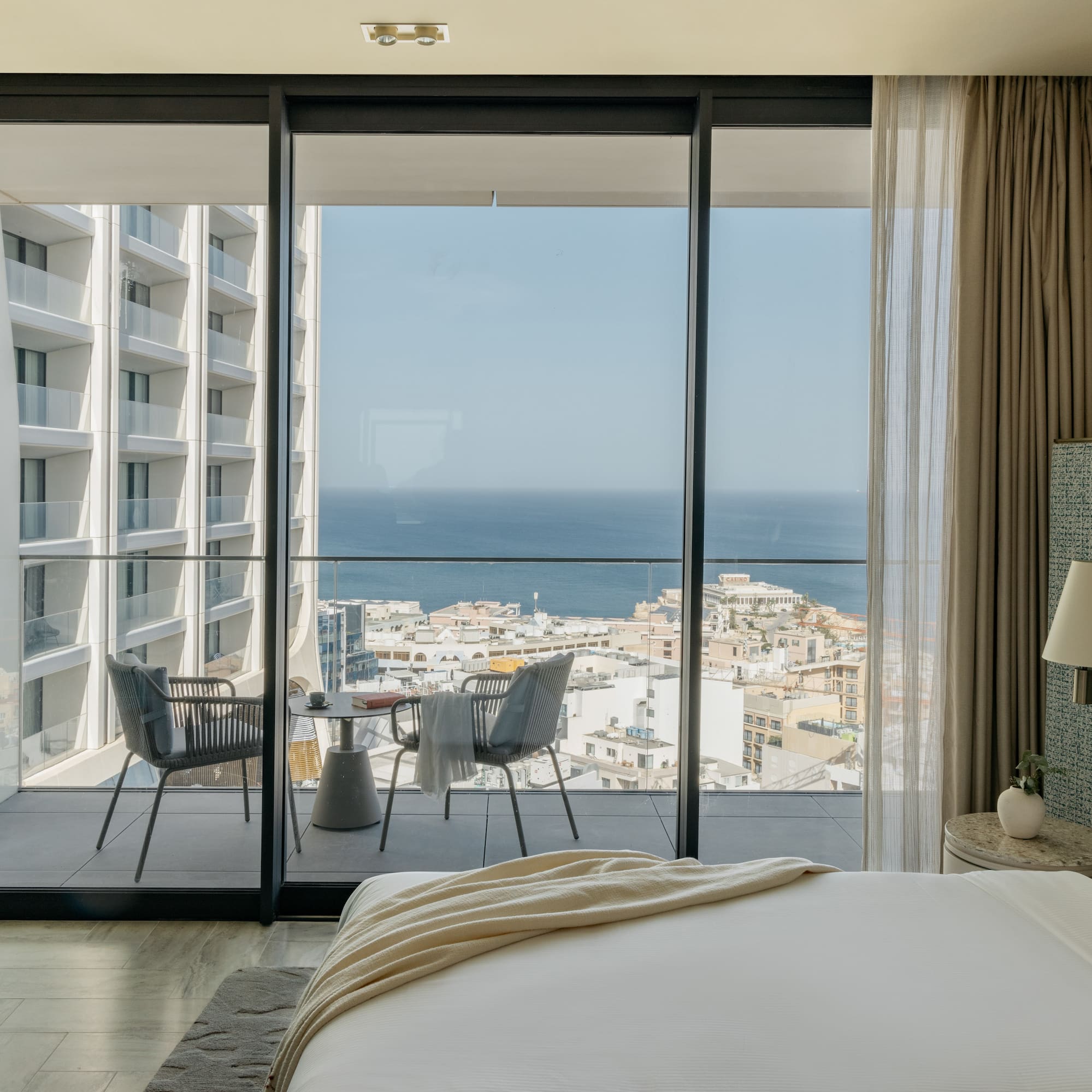 a bedroom with a view of the ocean and a city