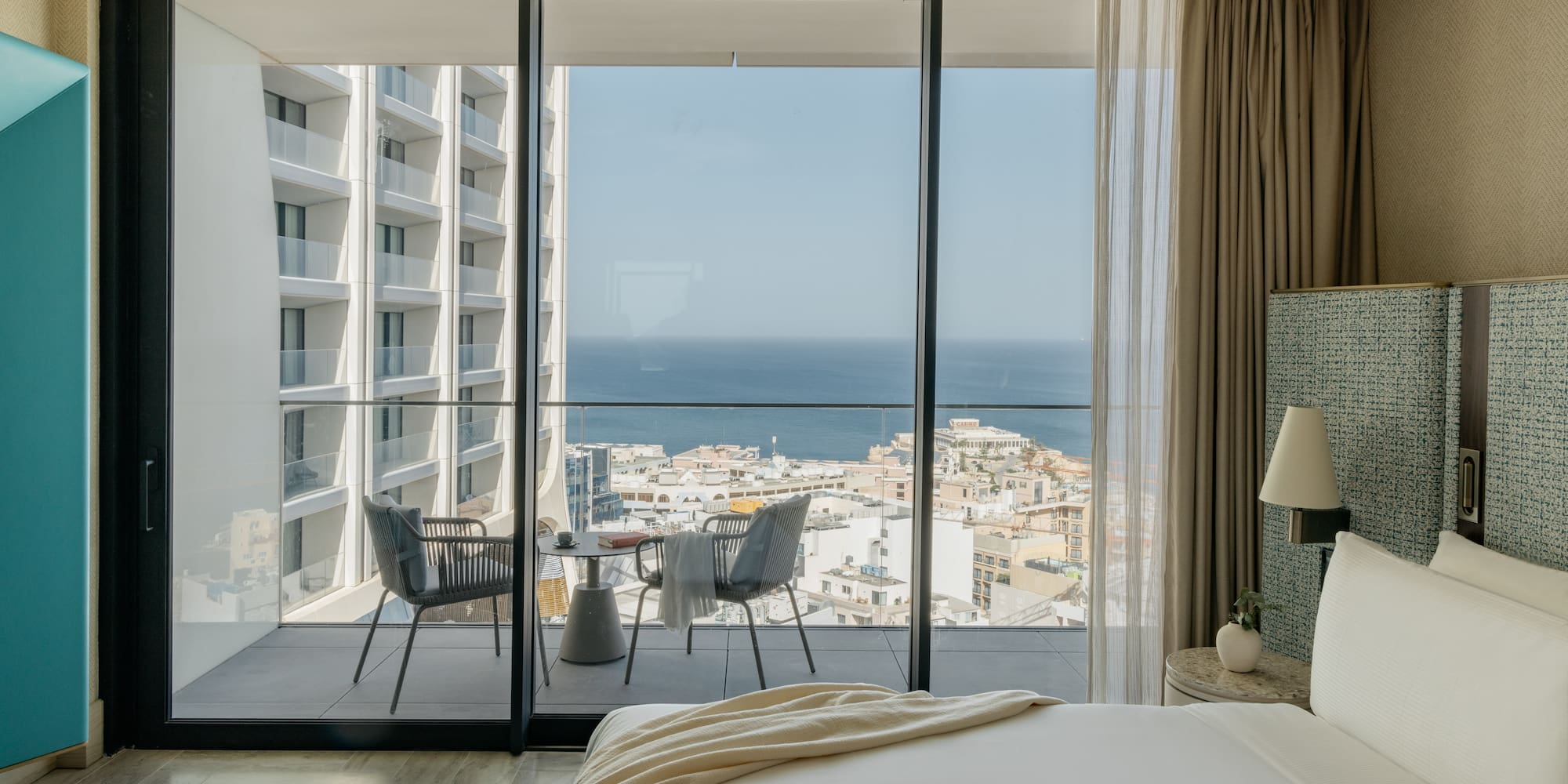 a bedroom with a view of the ocean and a city