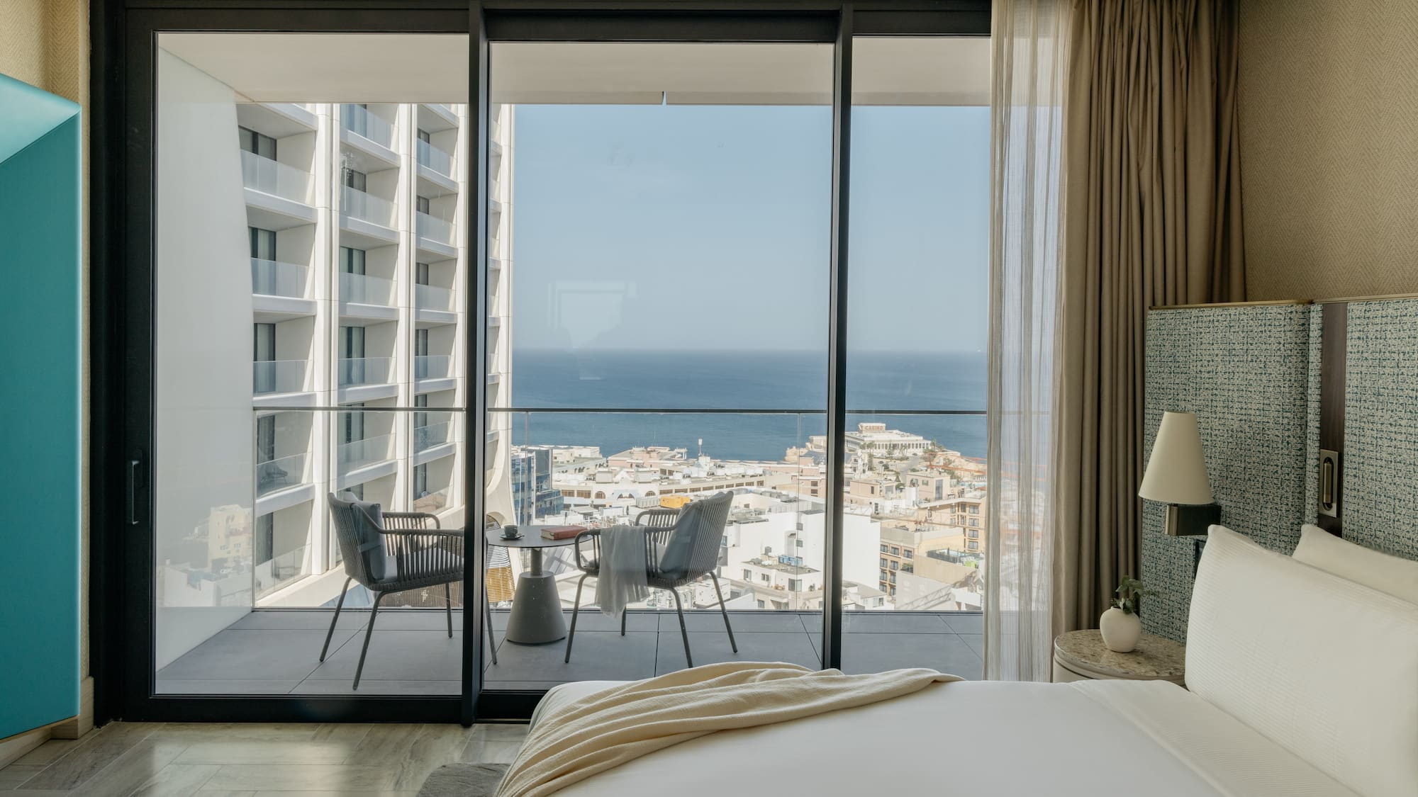 a bedroom with a view of the ocean and a city