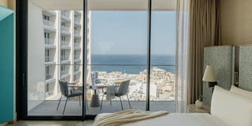 a bedroom with a view of the ocean and a city