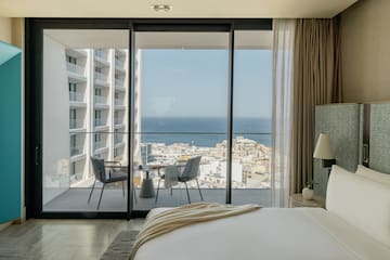 a bedroom with a view of the ocean and a city