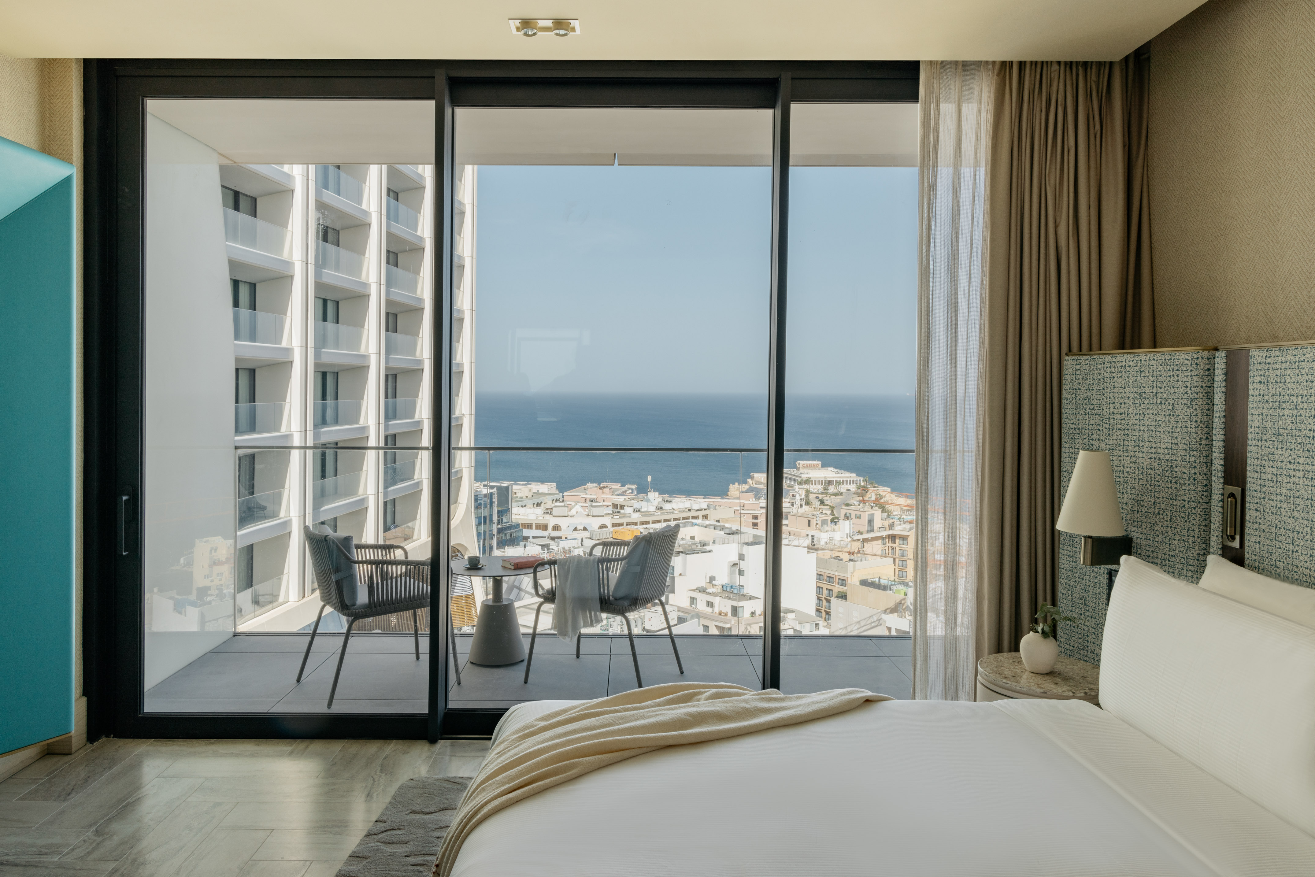 a bedroom with a view of the ocean and a city