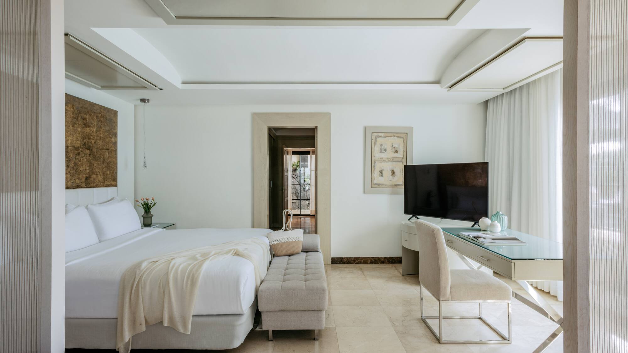 a bedroom with a large bed and a desk