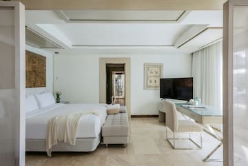 a bedroom with a large bed and a desk