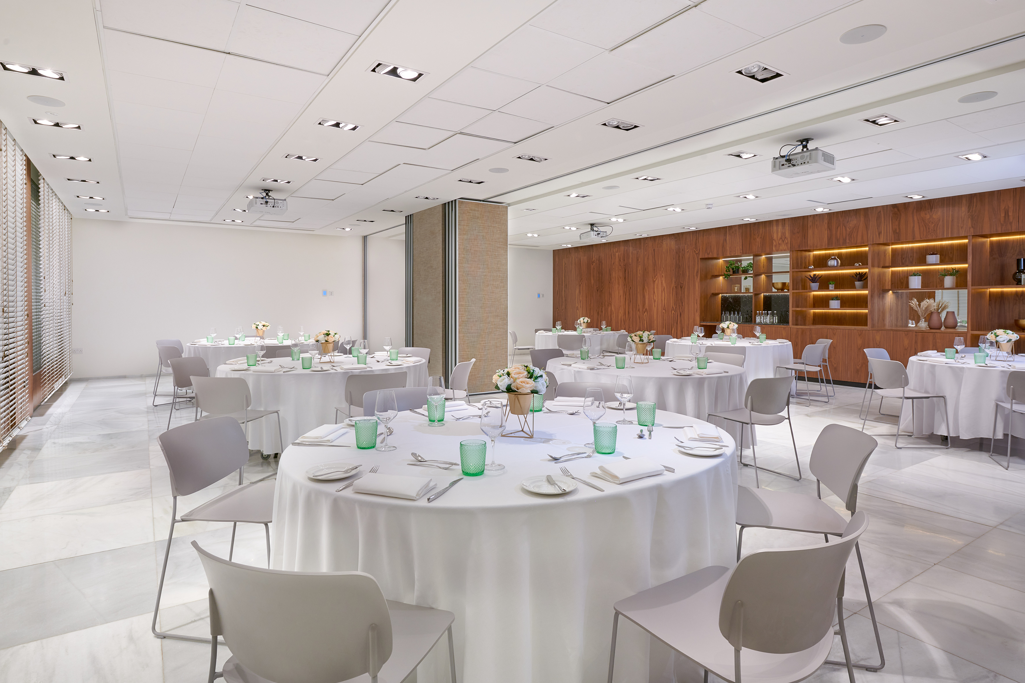 Elegant banquet hall with round tables, modern decor, and wood accents.