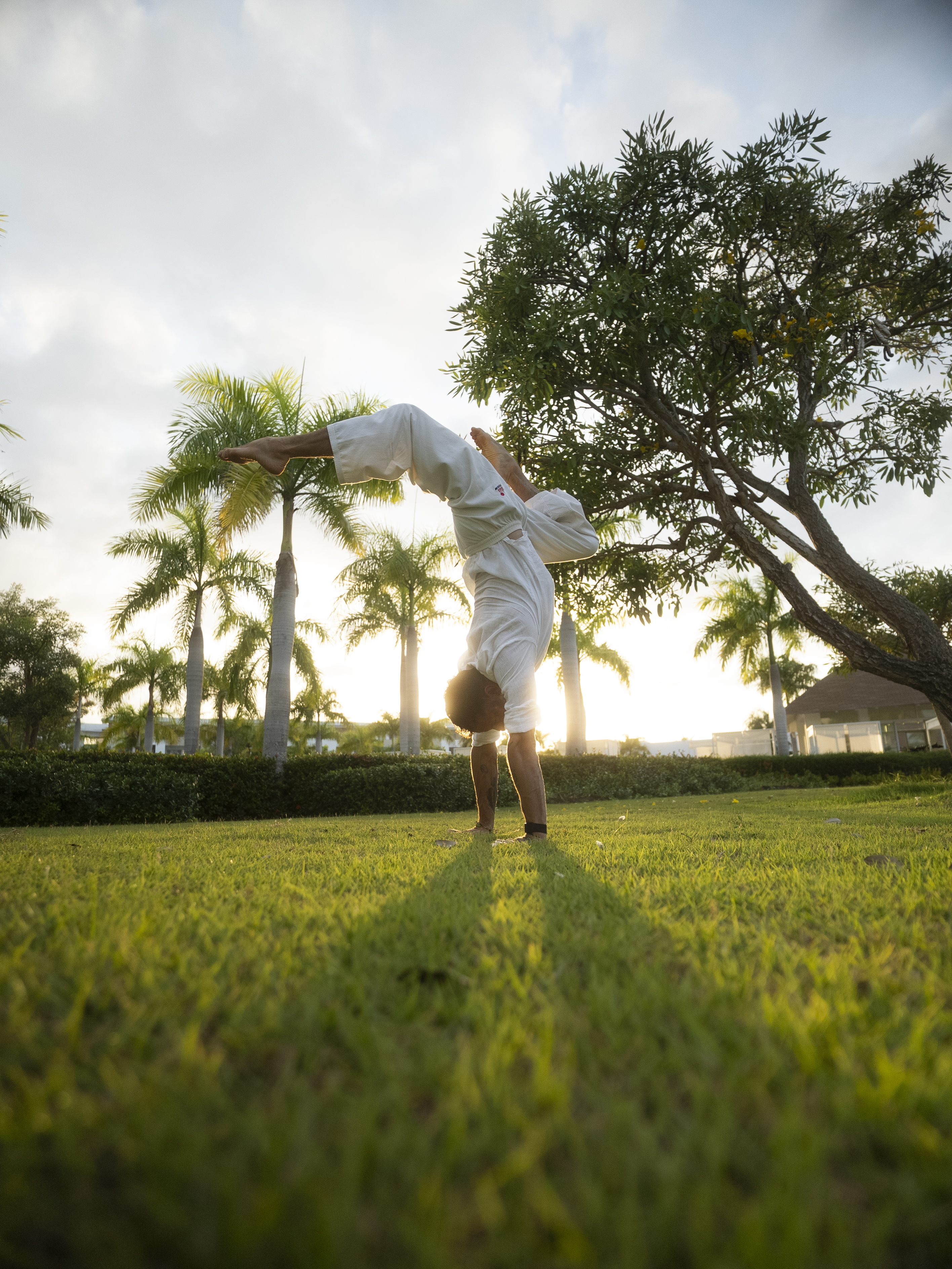 a man doing a hand stand on grass