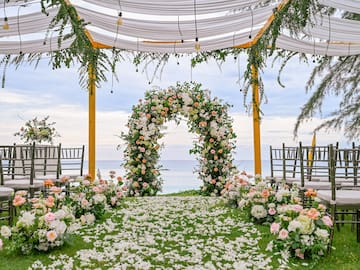 a wedding ceremony with flowers and chairs