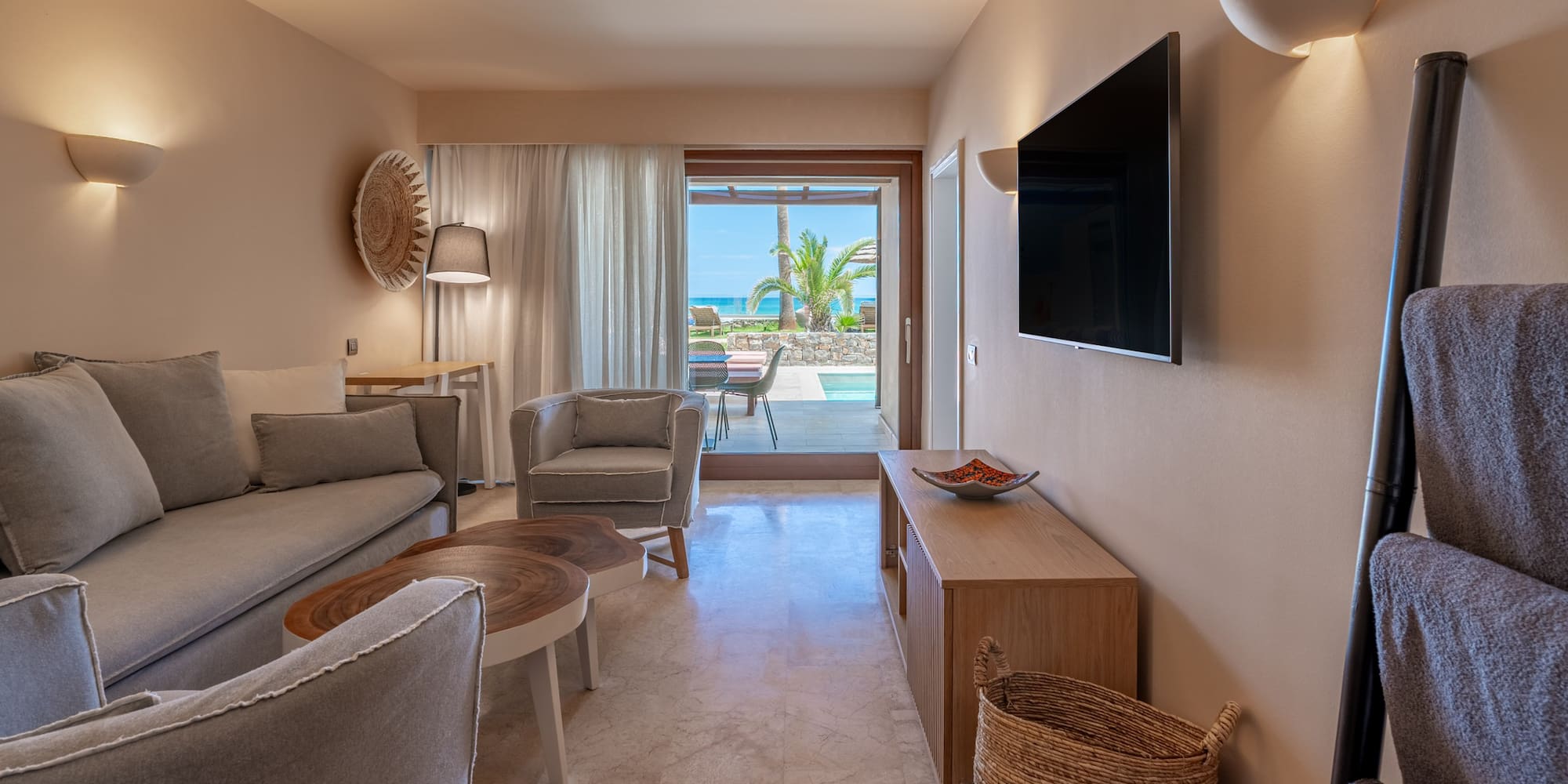 Modern suite living room, ocean view, private pool, sofa, TV.