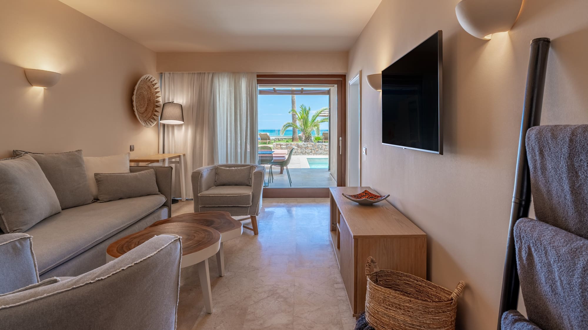 Modern suite living room, ocean view, private pool, sofa, TV.