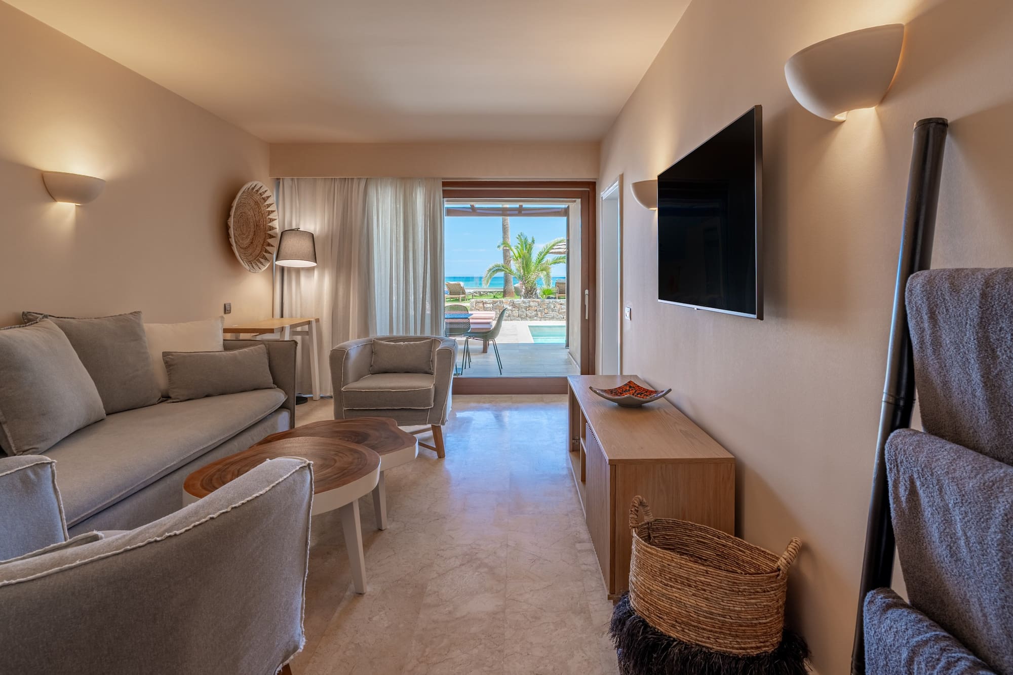 Modern suite living room, ocean view, private pool, sofa, TV.