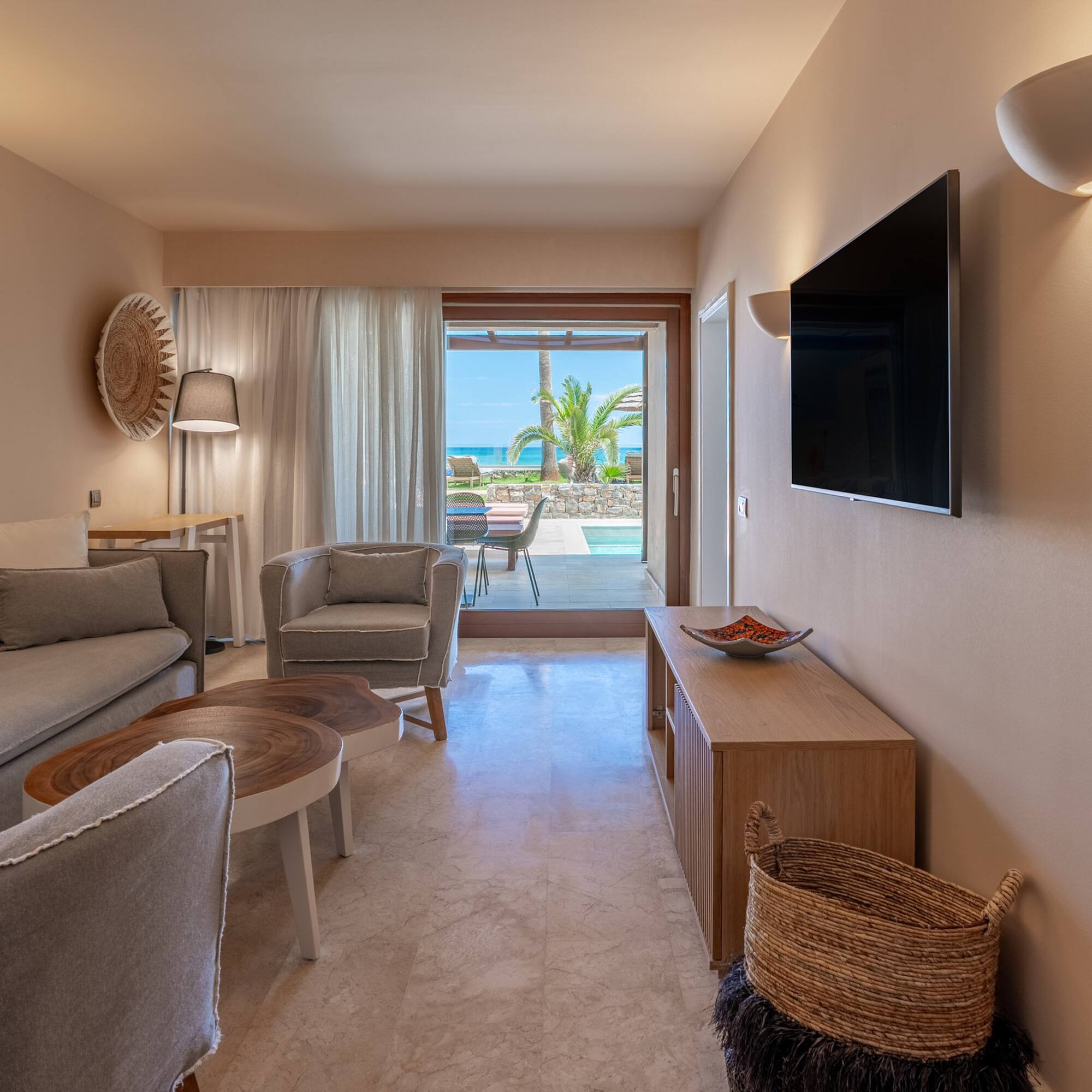 Modern suite living room, ocean view, private pool, sofa, TV.