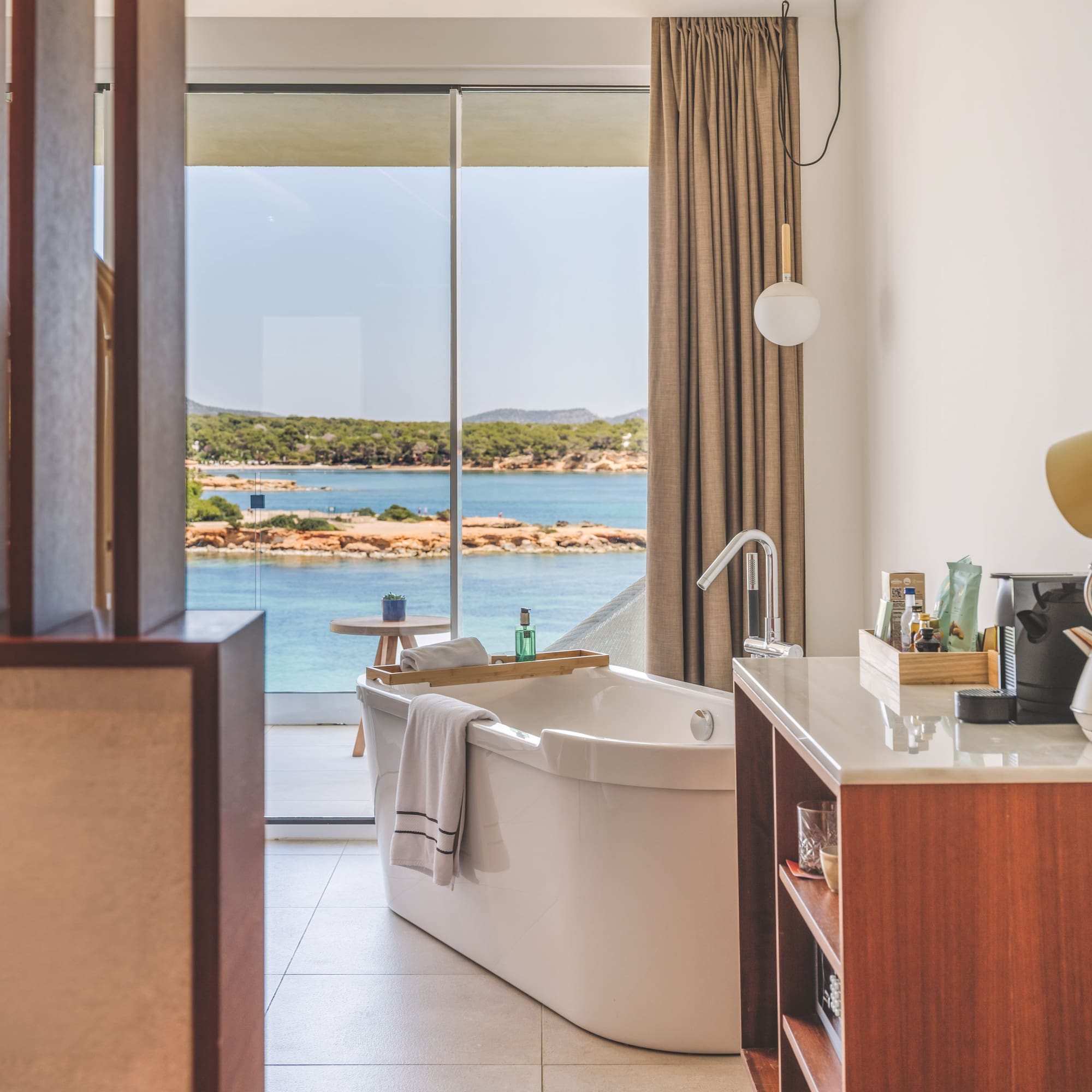 Modern bathroom with freestanding tub and stunning ocean view.