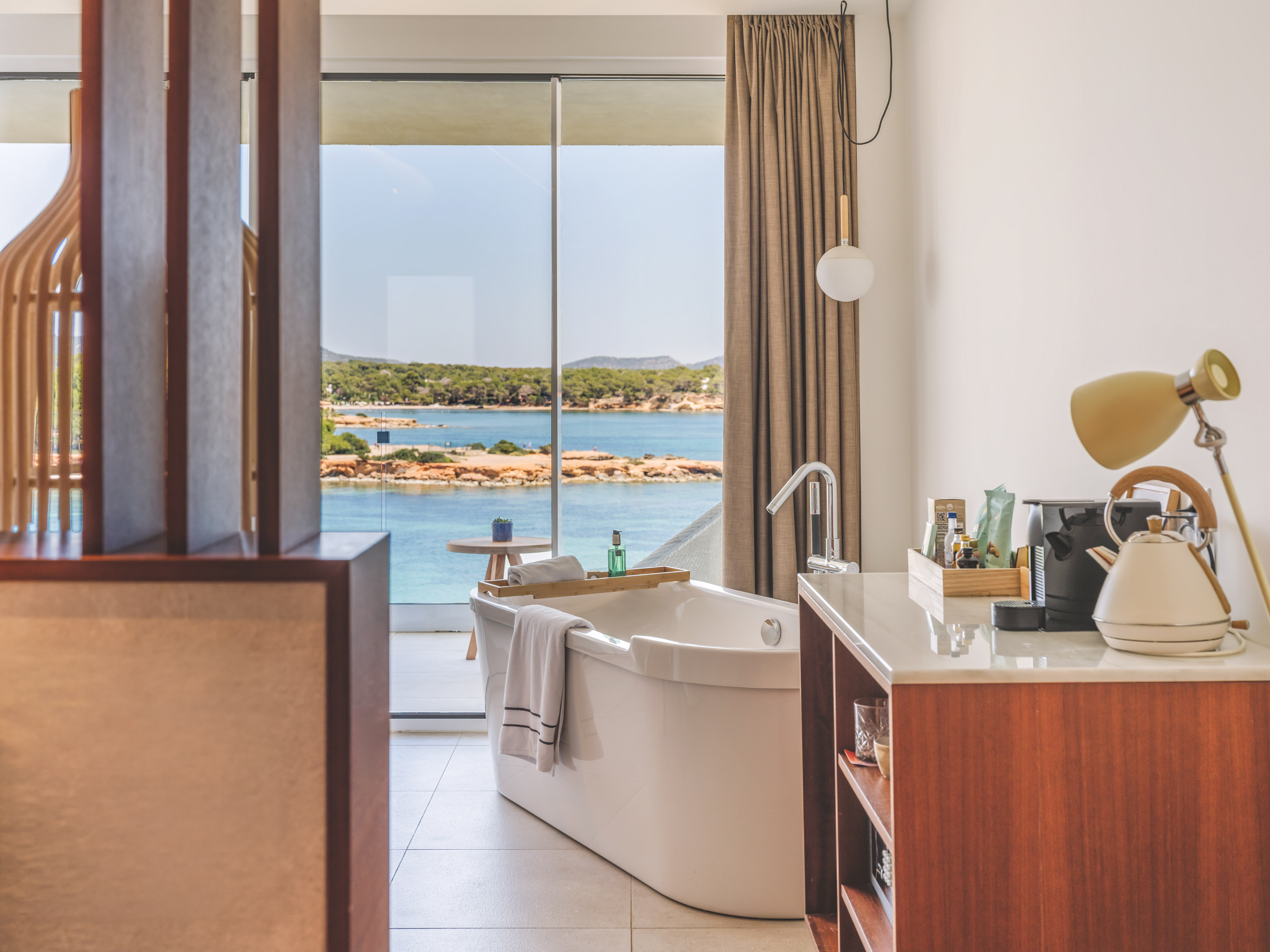 Modern bathroom with freestanding tub and stunning ocean view.