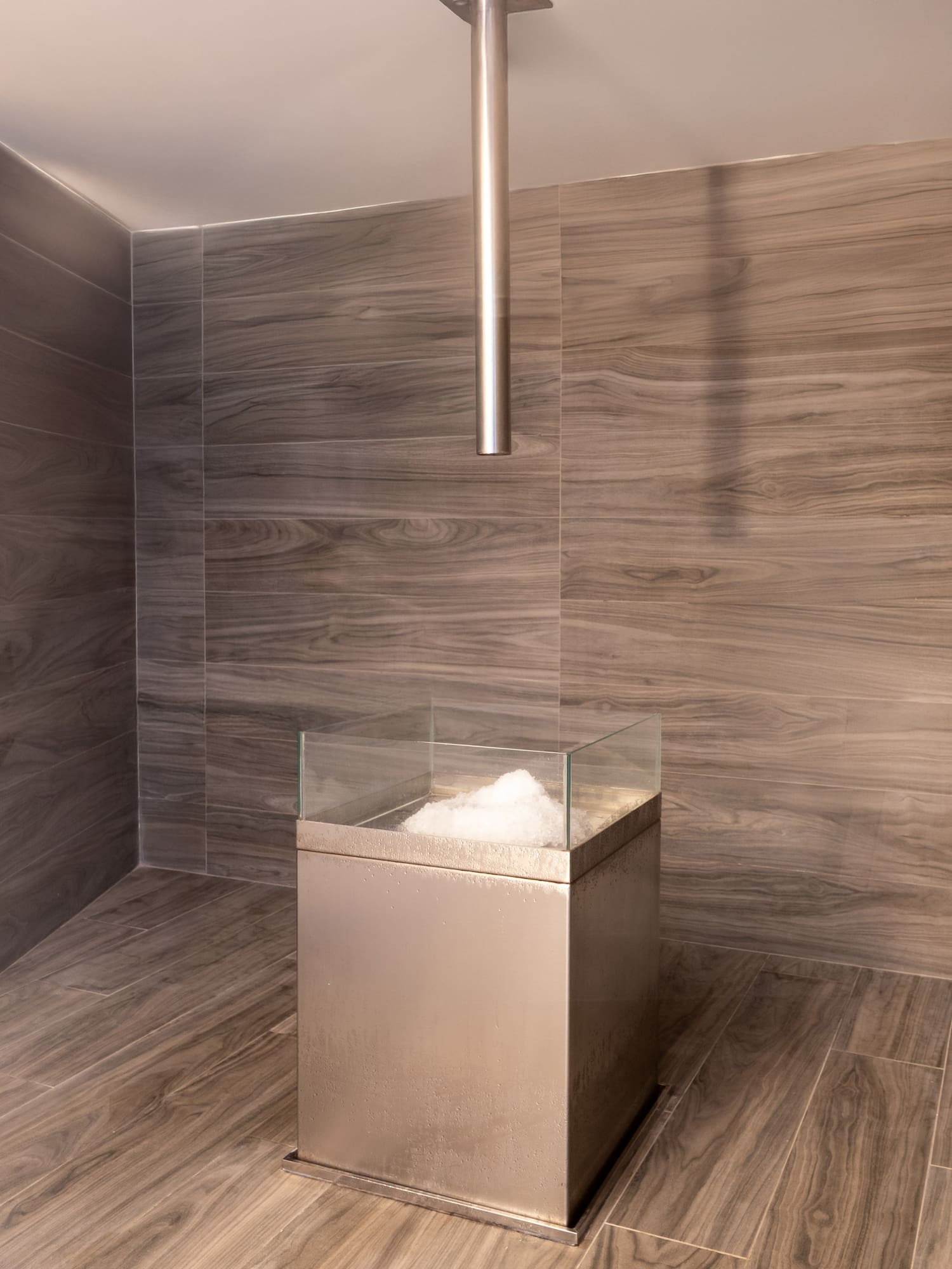 a glass box with a glass top in a room with wood walls