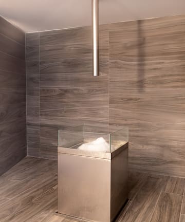 a glass box with a glass top in a room with wood walls