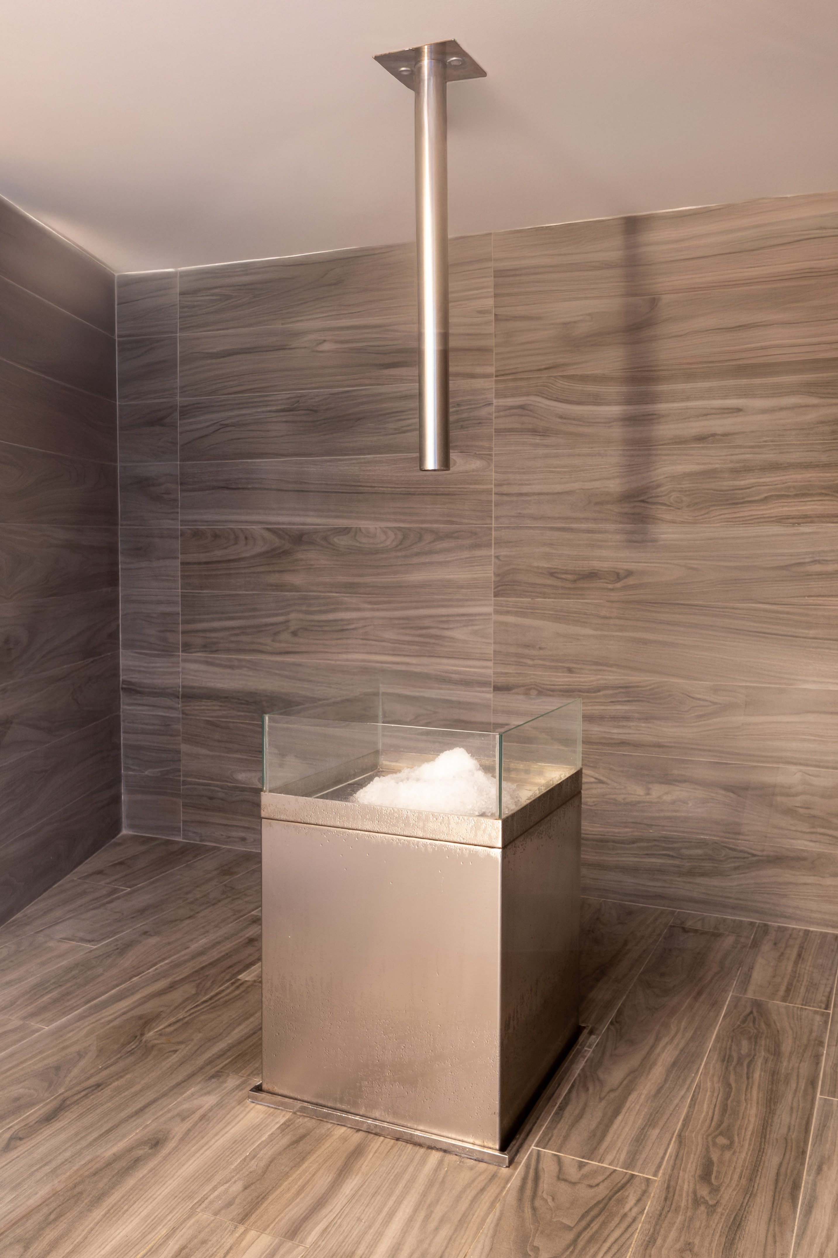 a glass box with a glass top in a room with wood walls