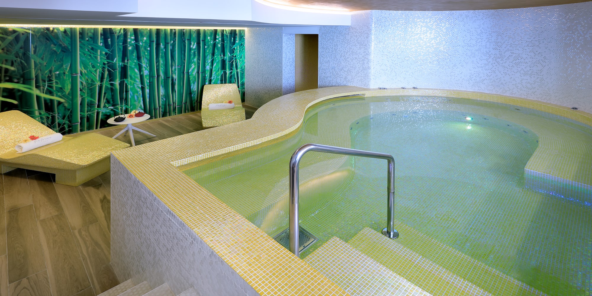 a indoor pool with stairs and a chair