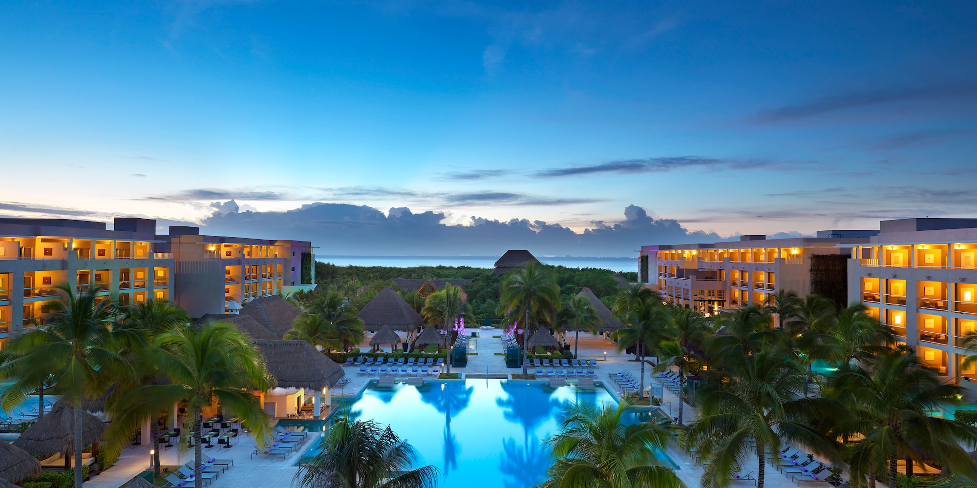 a pool with palm trees and buildings in the background