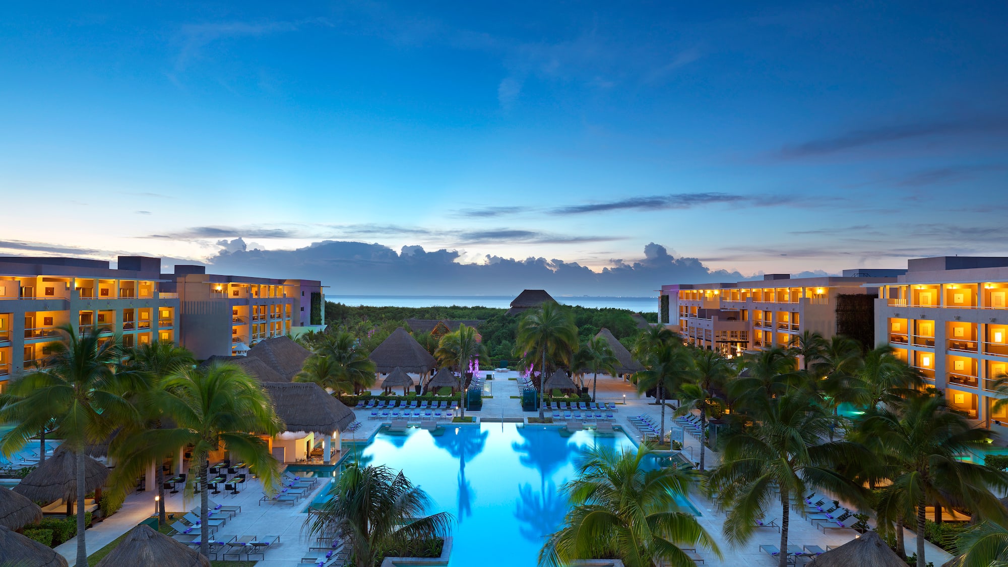 a pool with palm trees and buildings in the background