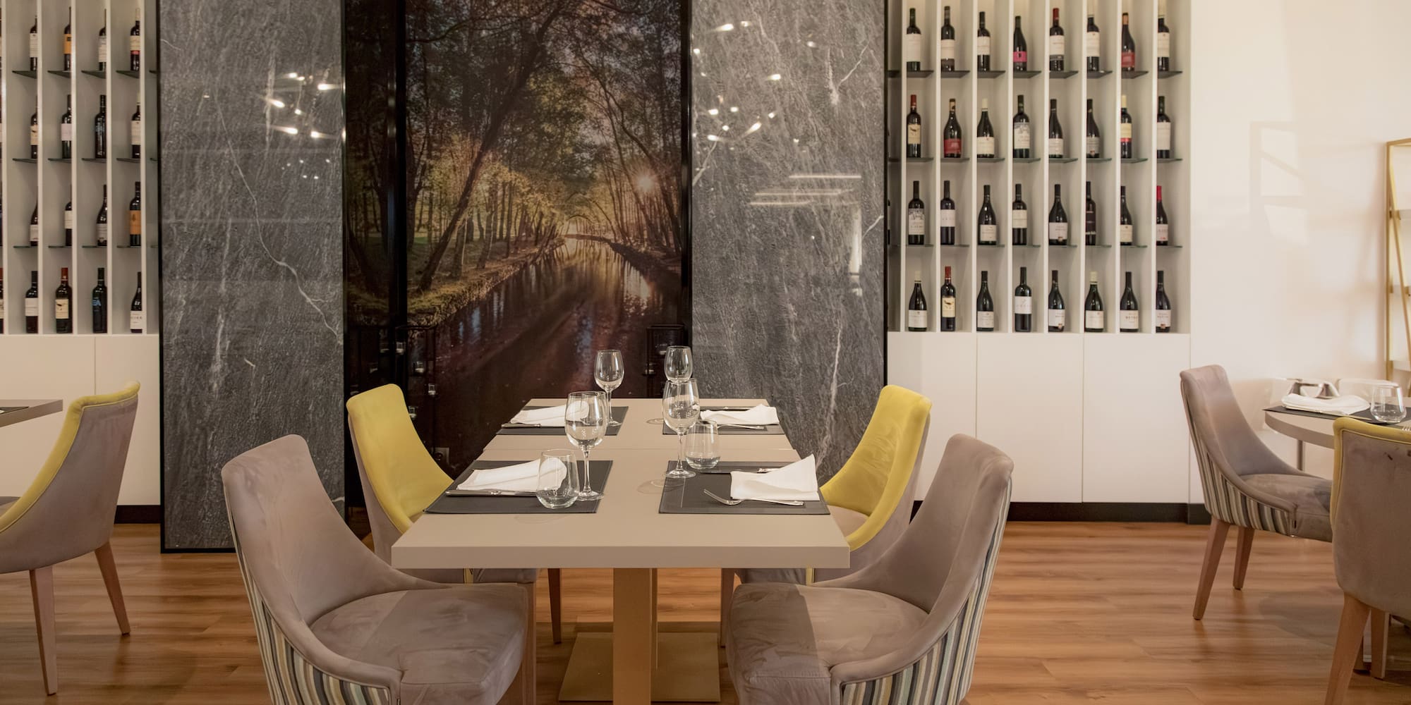 a table with wine glasses and chairs in a restaurant