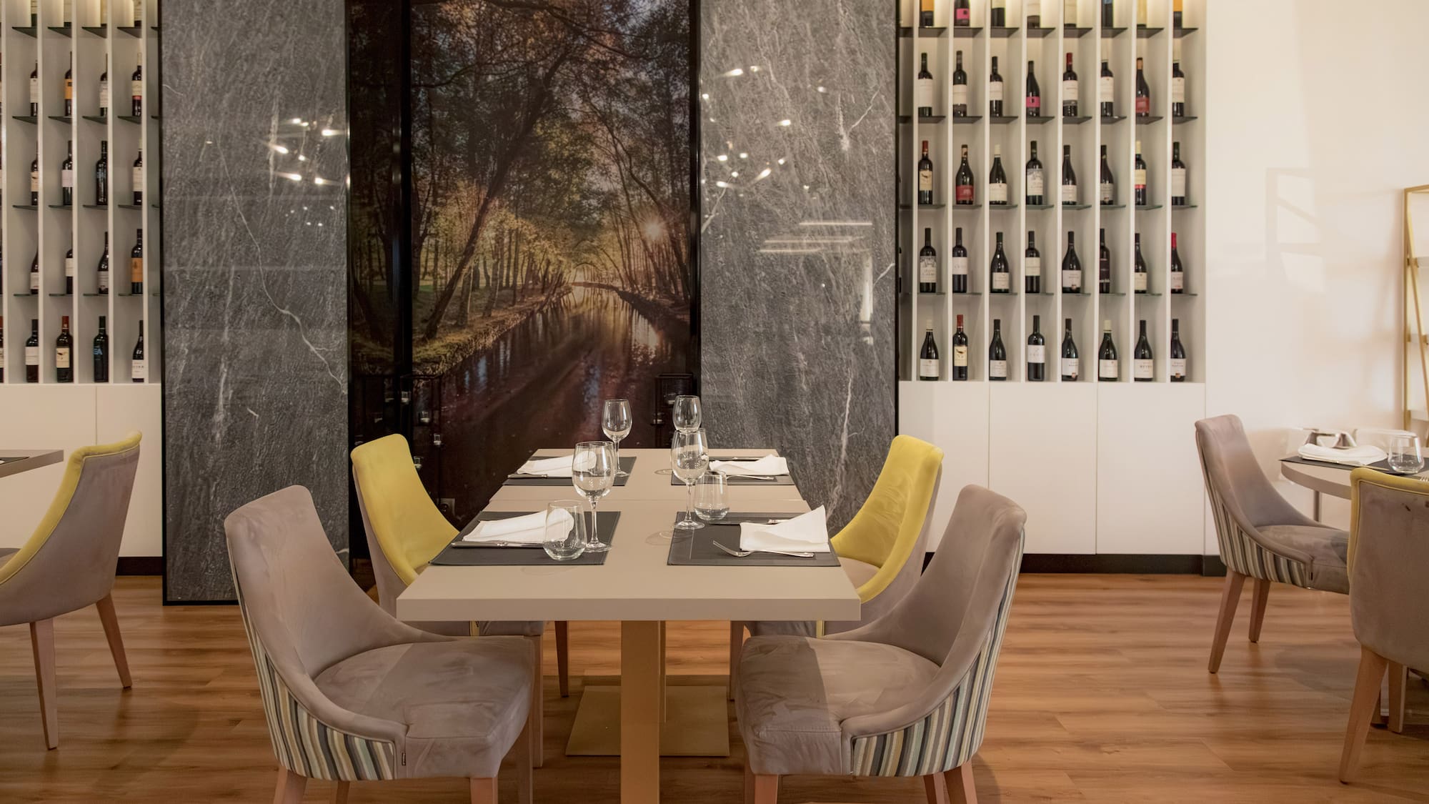 a table with wine glasses and chairs in a restaurant