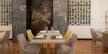 a table with wine glasses and chairs in a restaurant