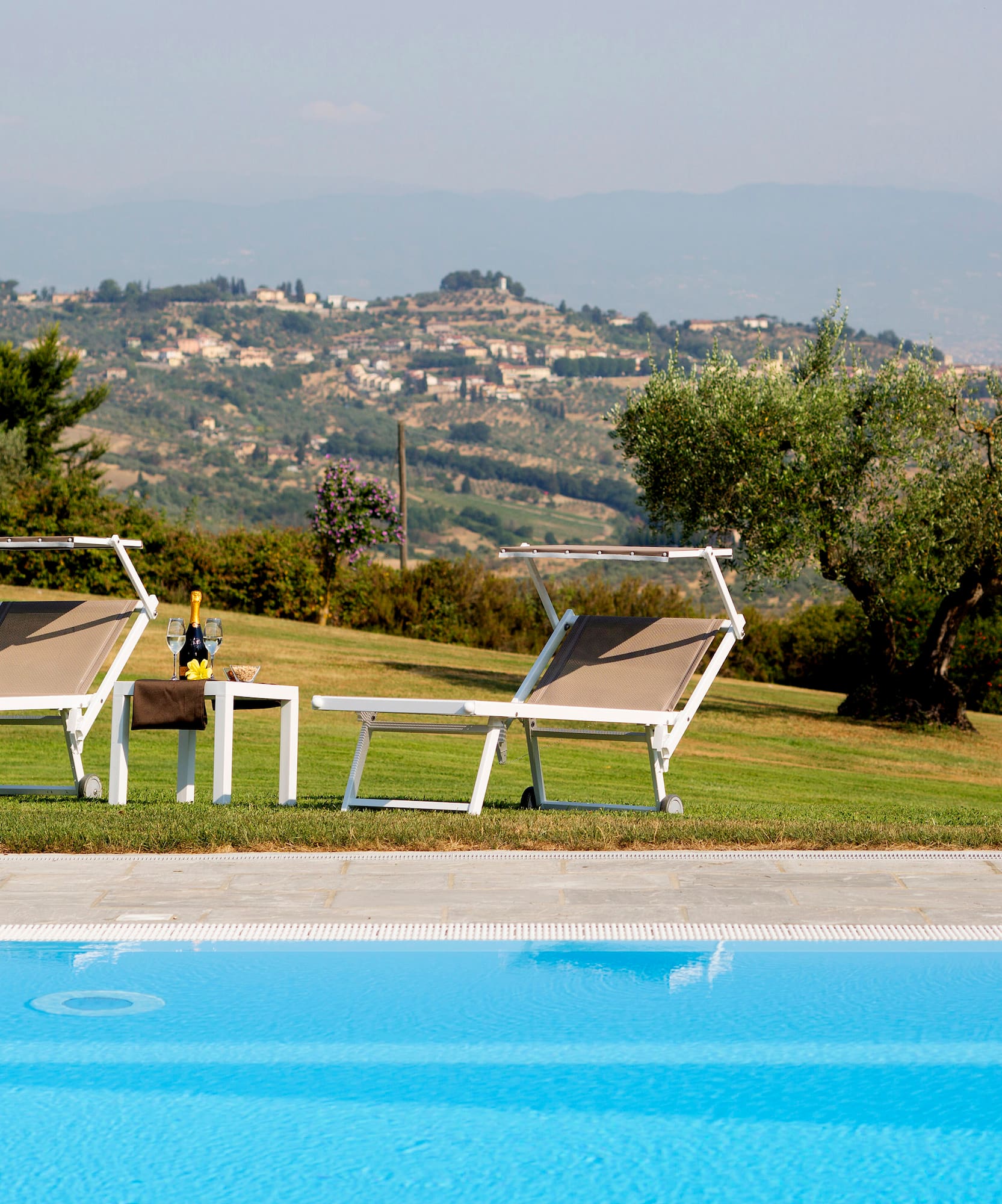 a pool with chairs and a table in front of it