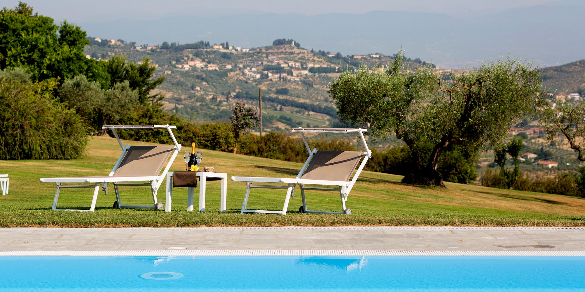 a pool with chairs and a table in front of it