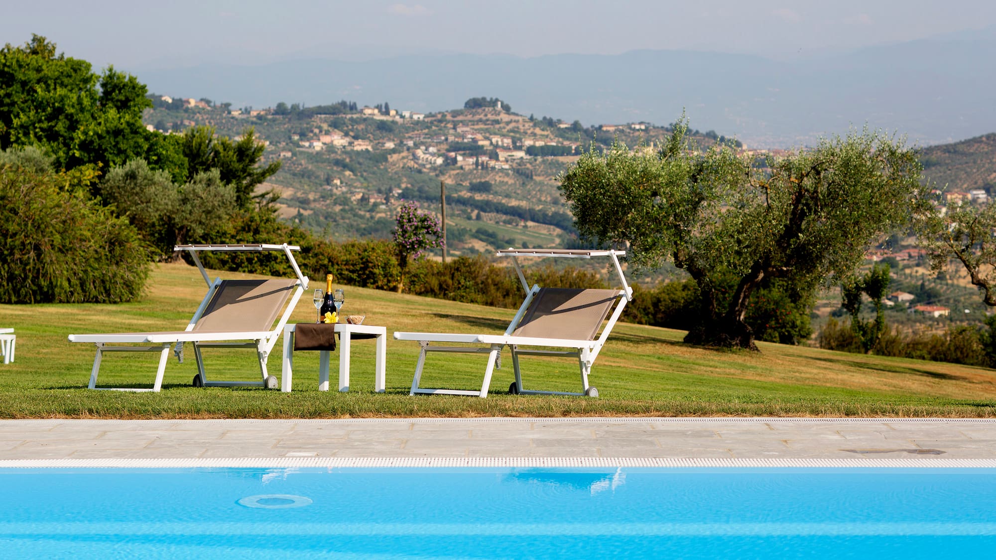 a pool with chairs and a table in front of it