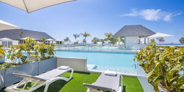 a pool with lounge chairs and a gazebo