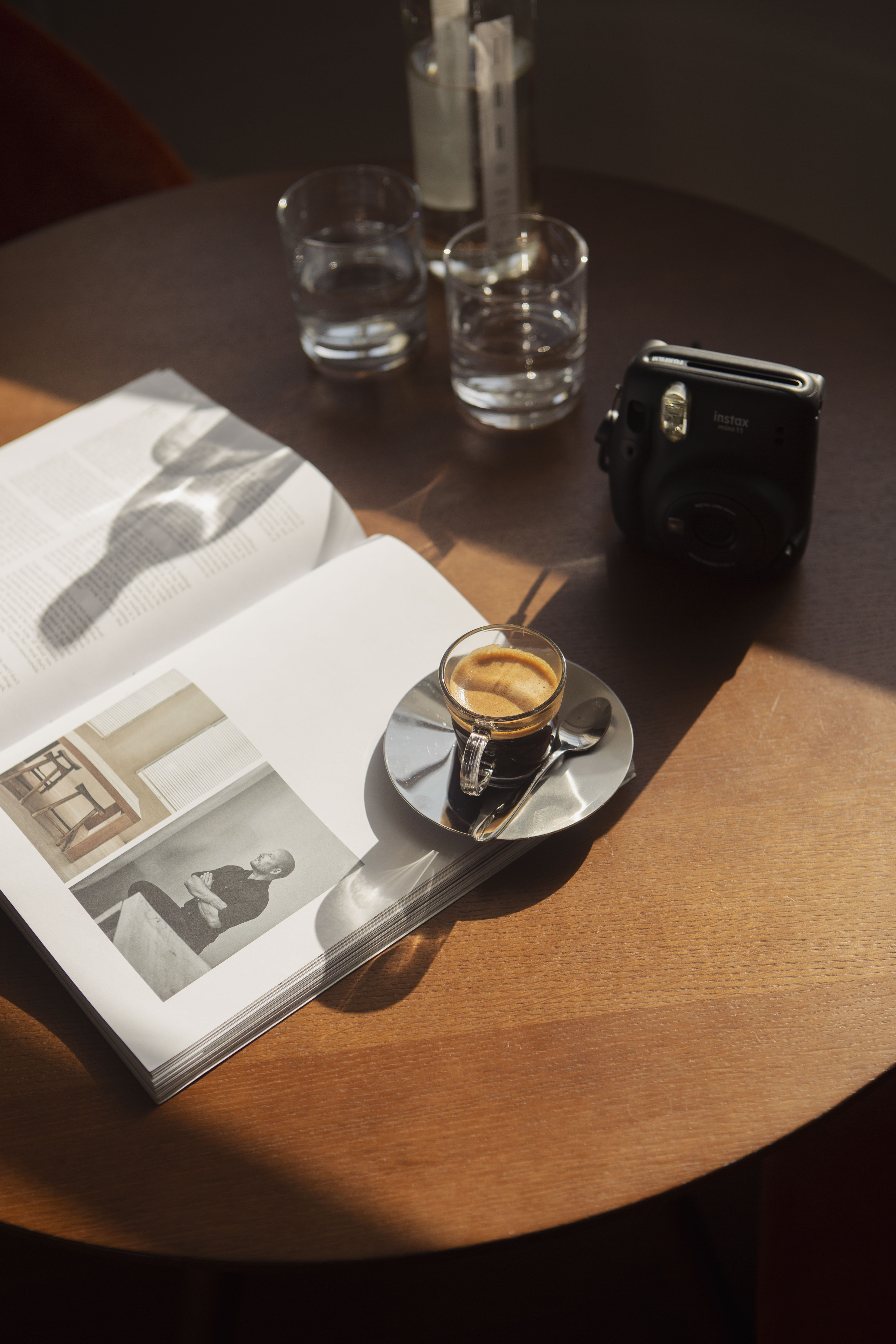 a cup of coffee on a saucer next to a book and glasses