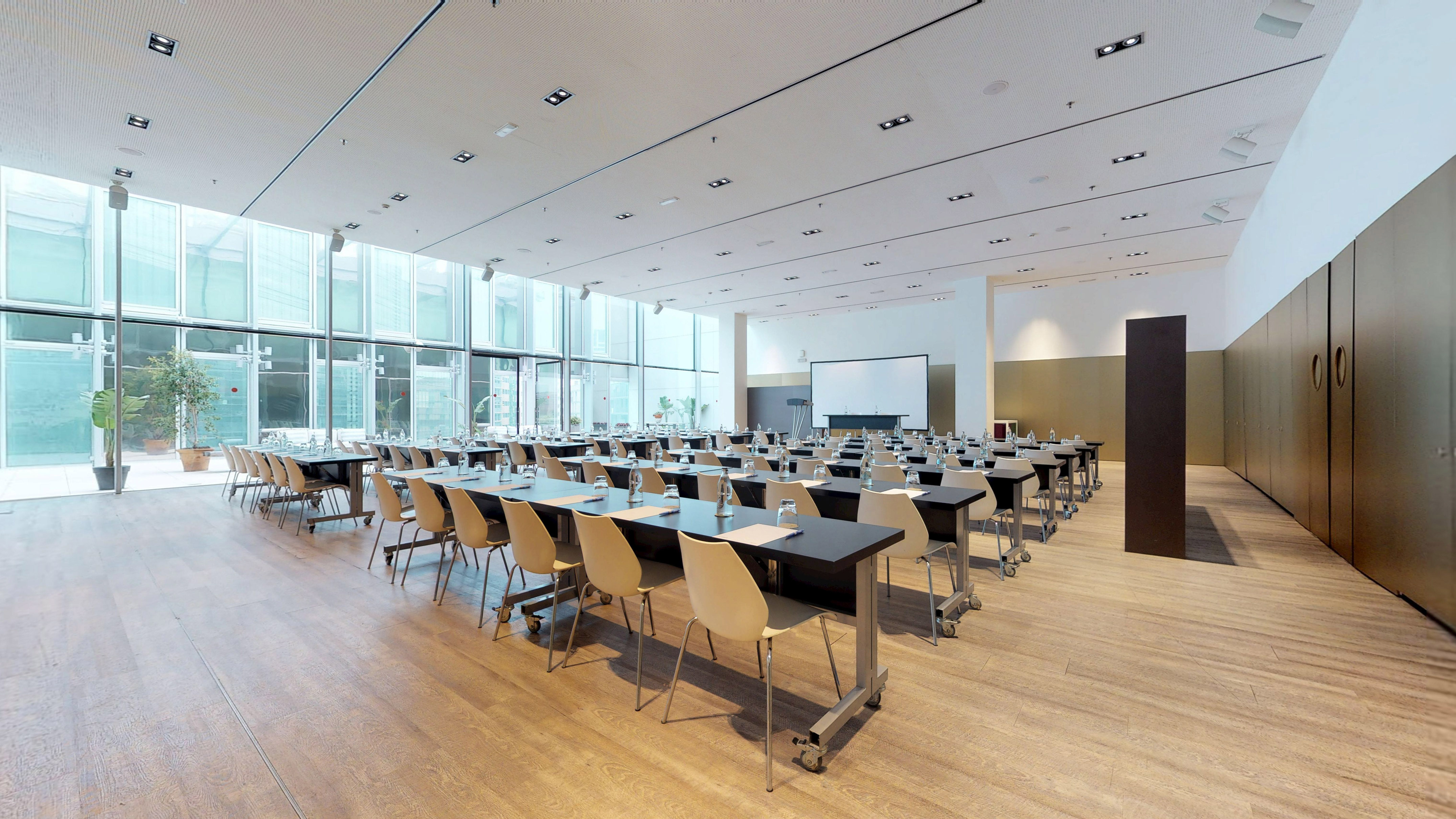 Modern meeting room with projection screen, tables, and large windows.