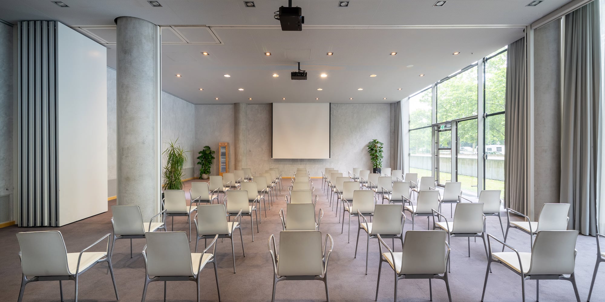 a room with many chairs and a projector screen