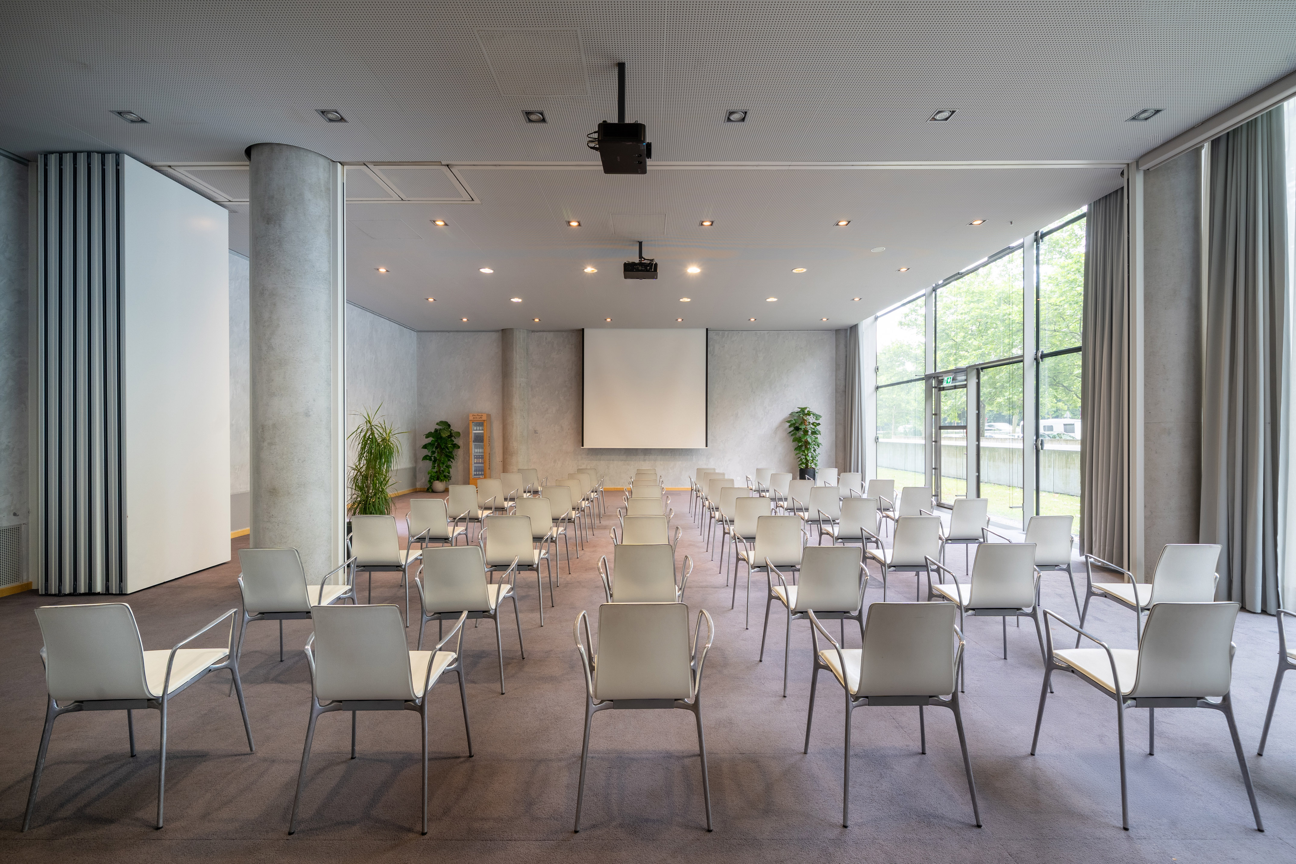 a room with many chairs and a projector screen